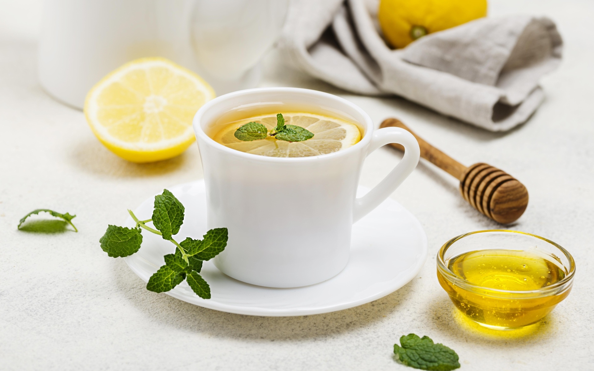 Белая кружка с чаем на столе с медом и лимоном