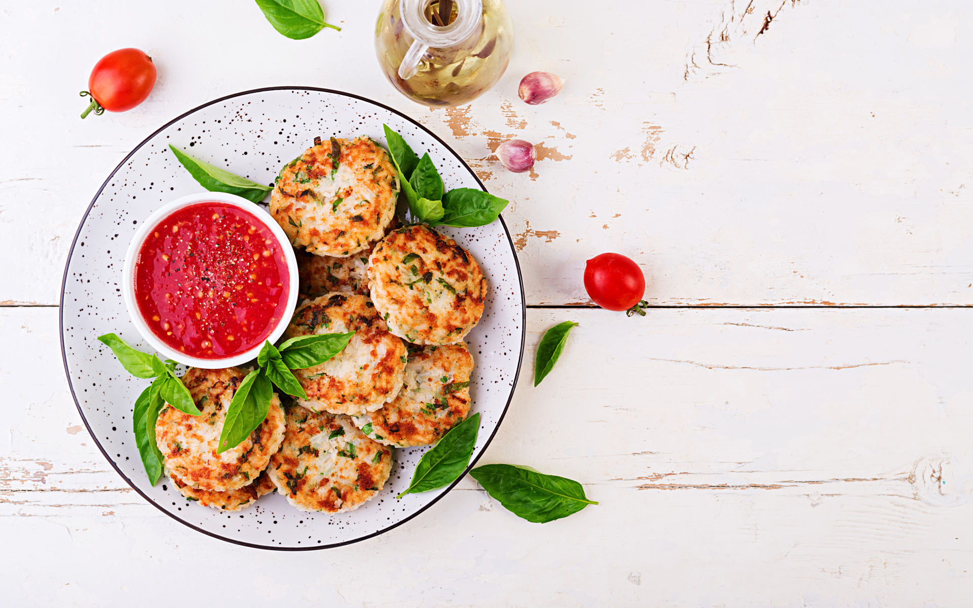 Куриные котлеты на большой белой тарелке  с соусом