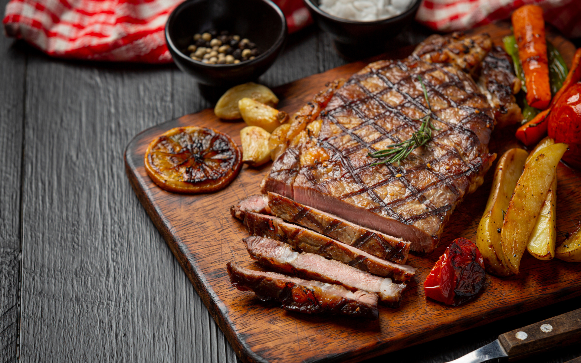 Кусок мясо барбекю на доске с овощами