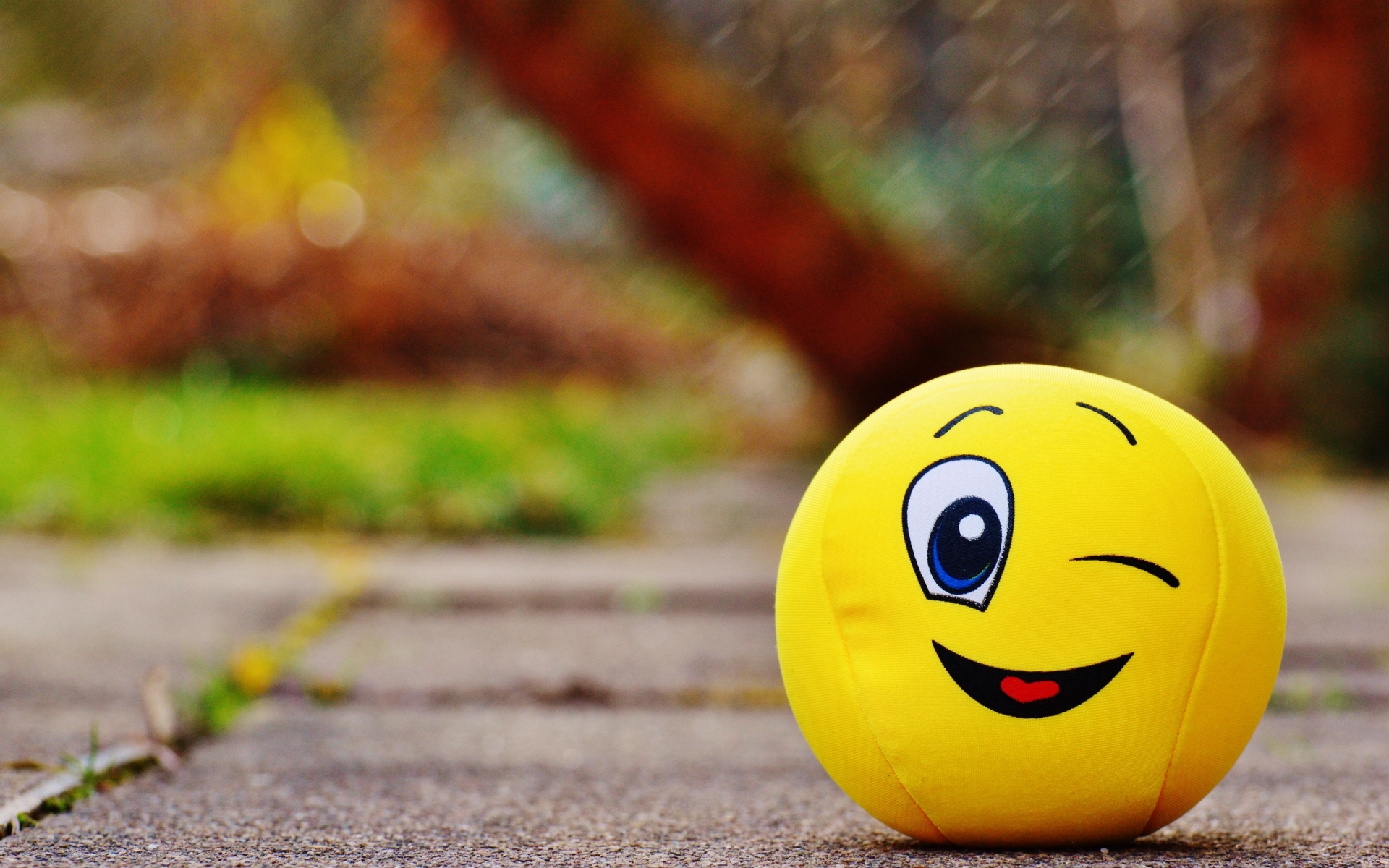 Желтый мягкий мяч смайл на дороге