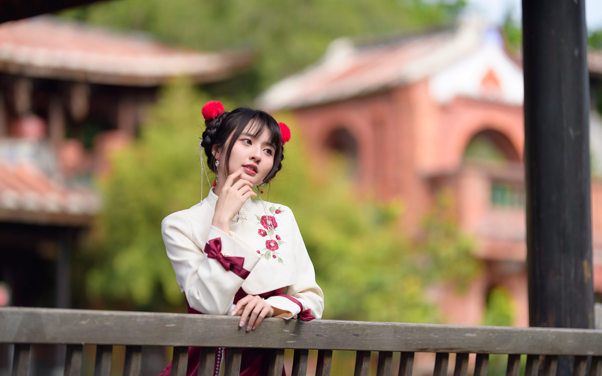 Девушка азиатка в народном костюме стоит у перил