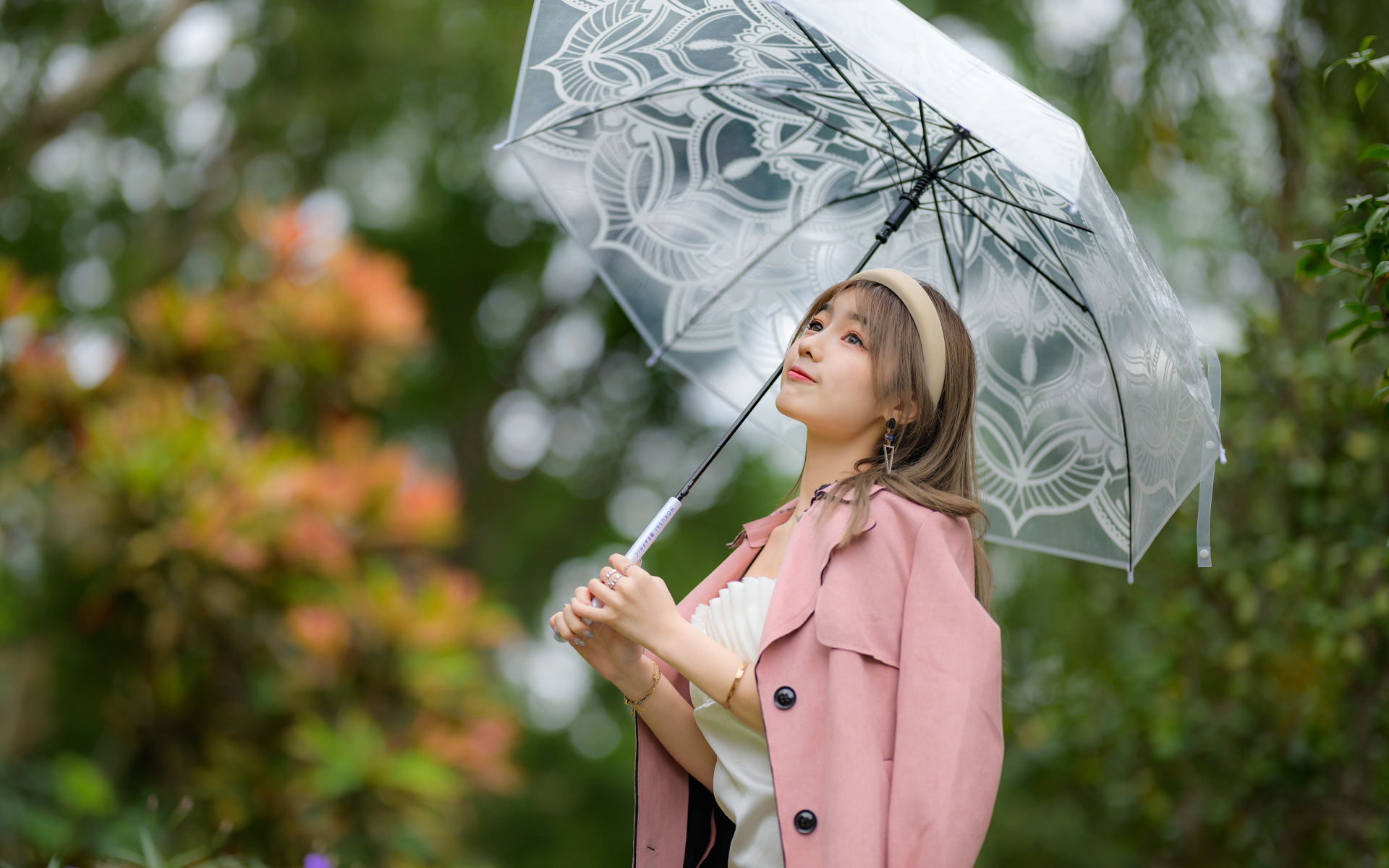 Девушка азиатка в пальто под прозрачным зонтом