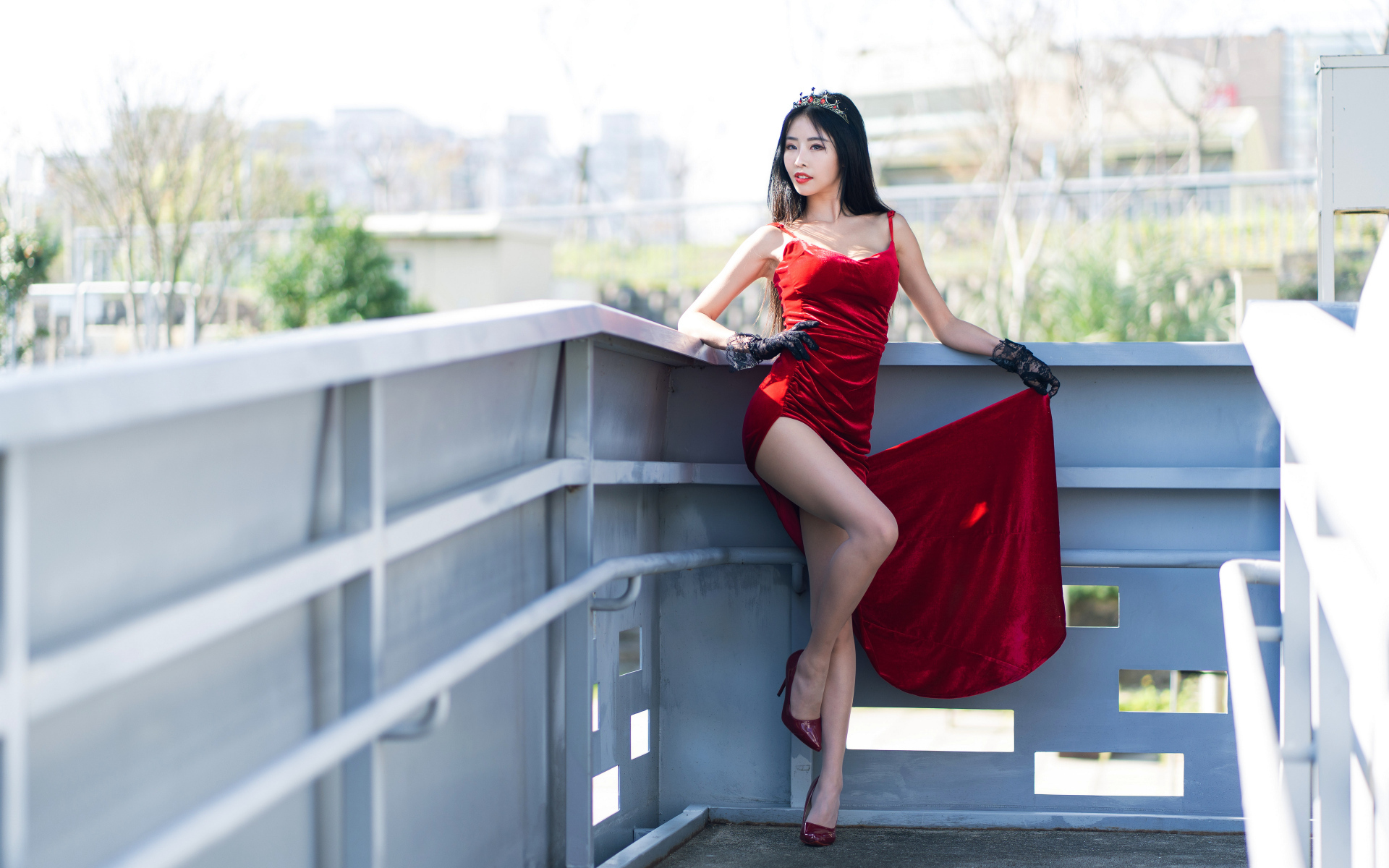 Азиатка в красном платье с короной на голове