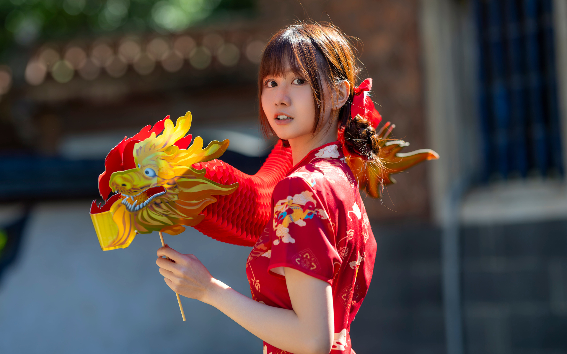 Азиатка в красном платье с бумажным драконом
