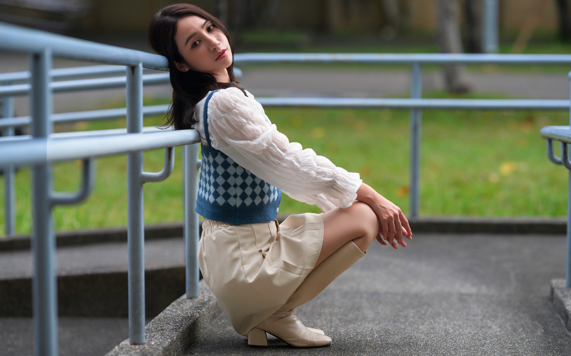 Милая девушка азиатка сидит у перил