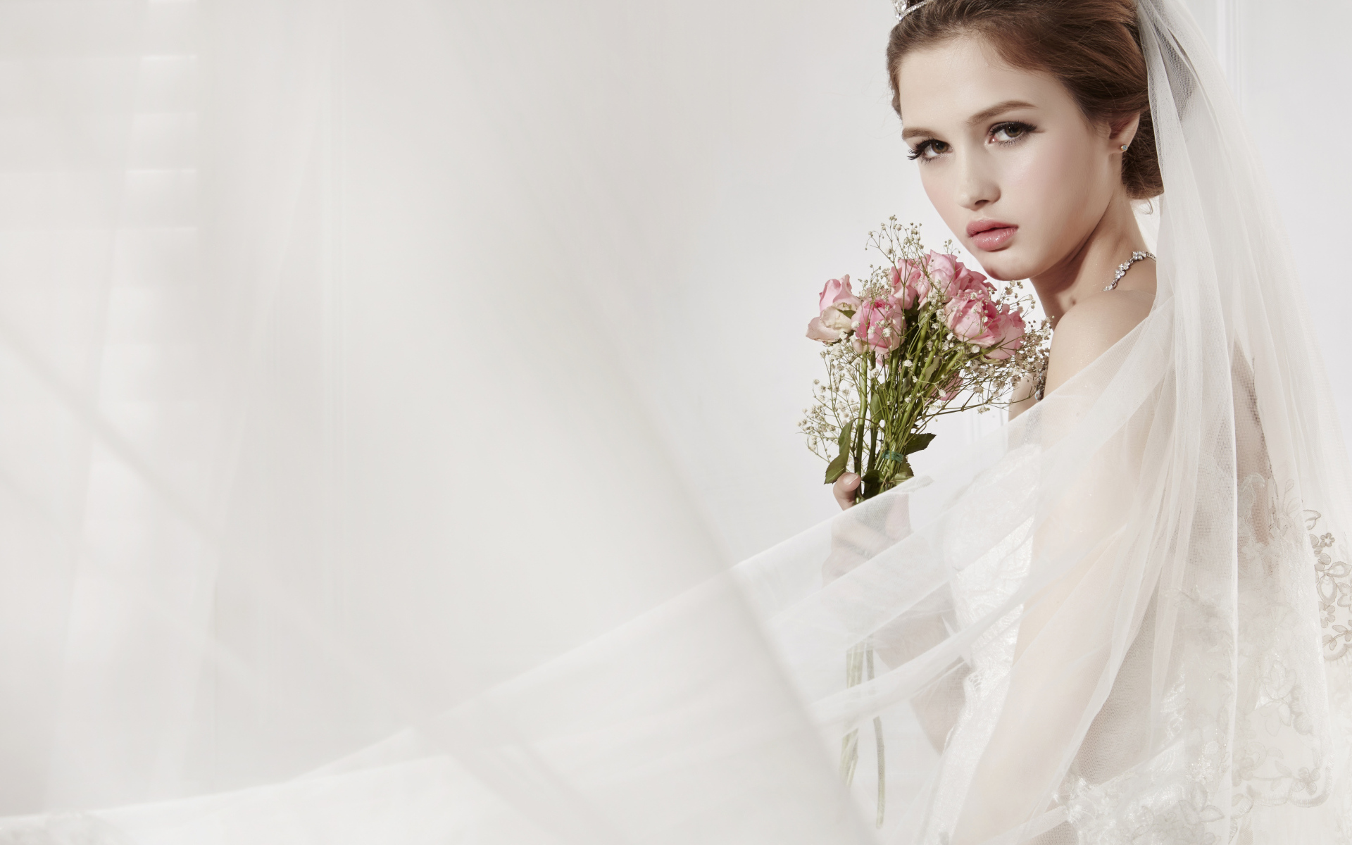 Милая девушка в костюме невесты с букетом цветов