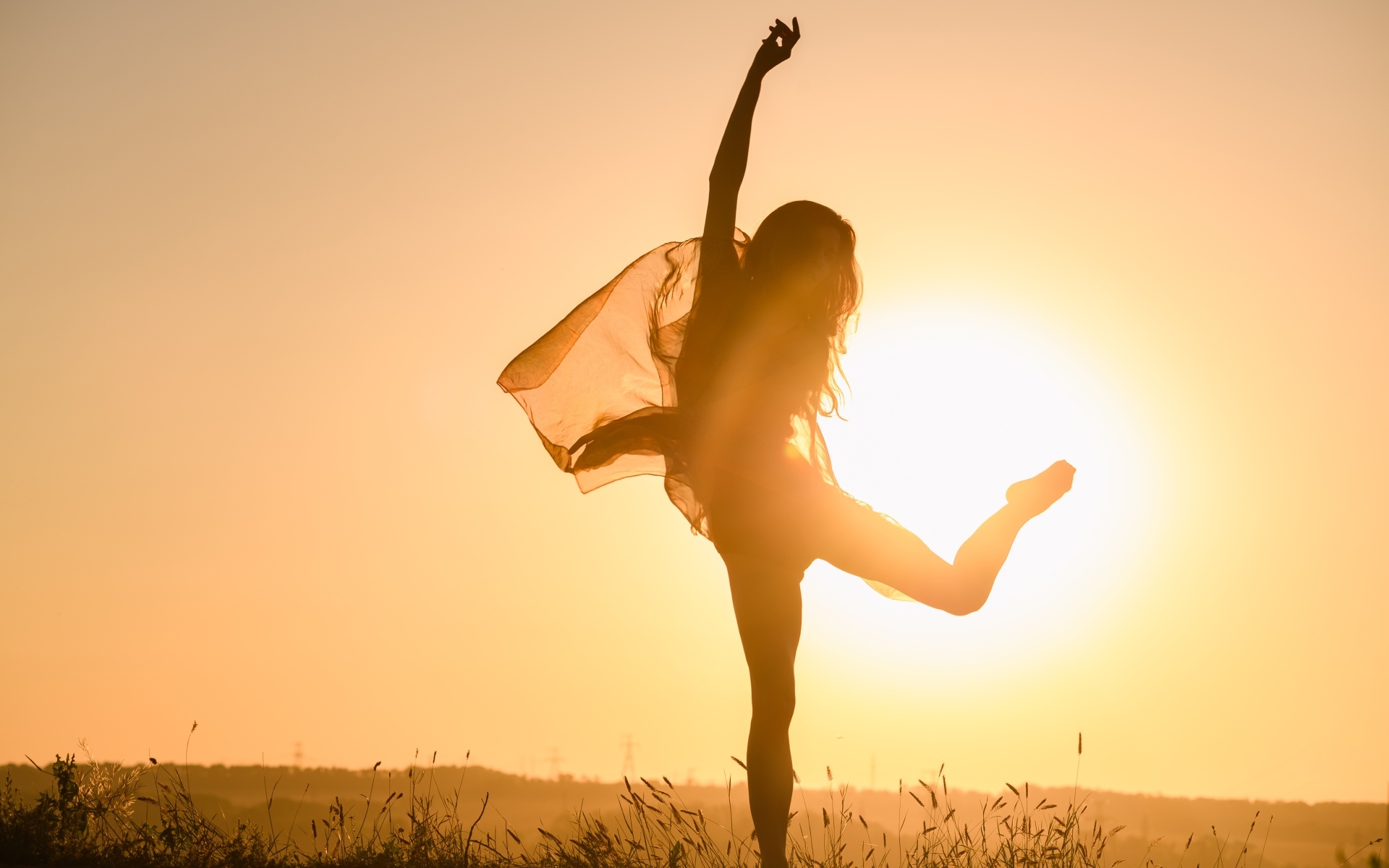 Девушка танцует в лучах солнца на закате