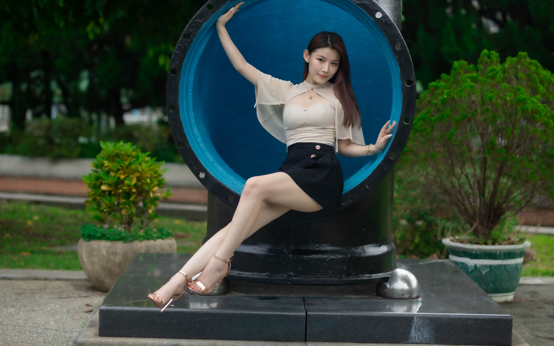 Стройная длинноногая азиатка сидит в трубе