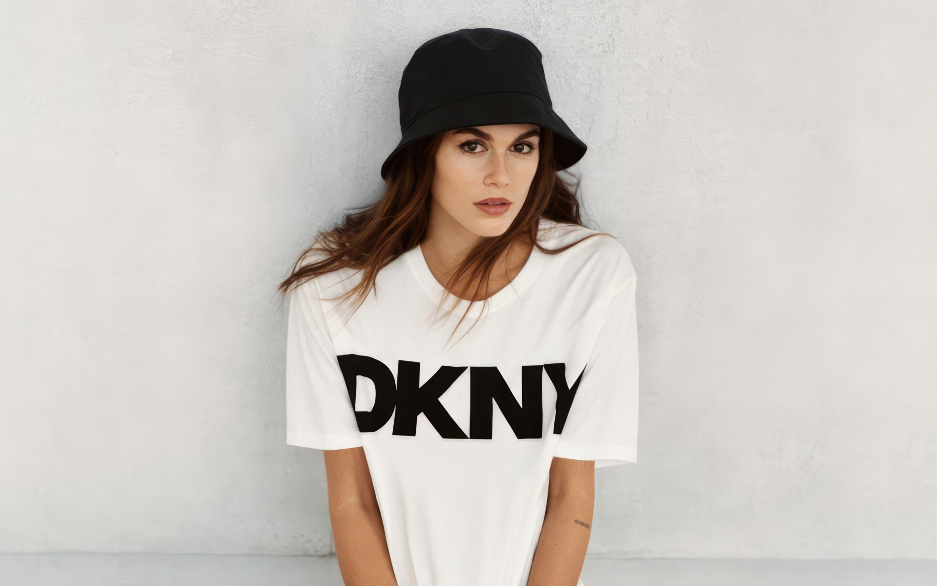 Американская модель Кайя Гербер в черной панаме у стены