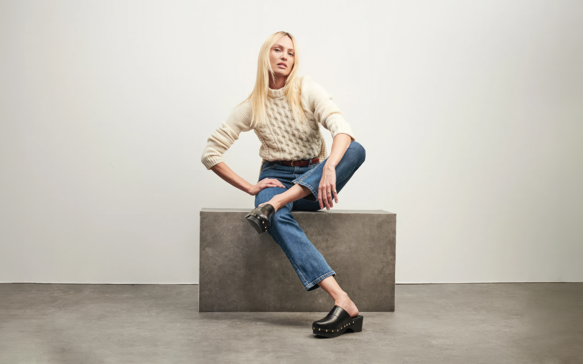 Модель Кэндис Свейнпол сидит на фоне серой стены