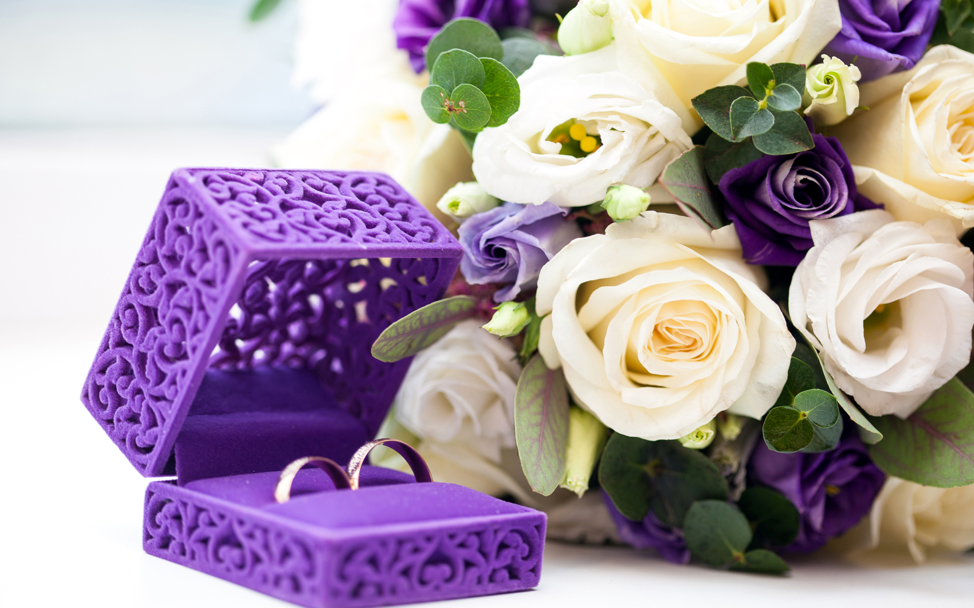 Красивая коробочка с кольцами и букетом цветов на столе