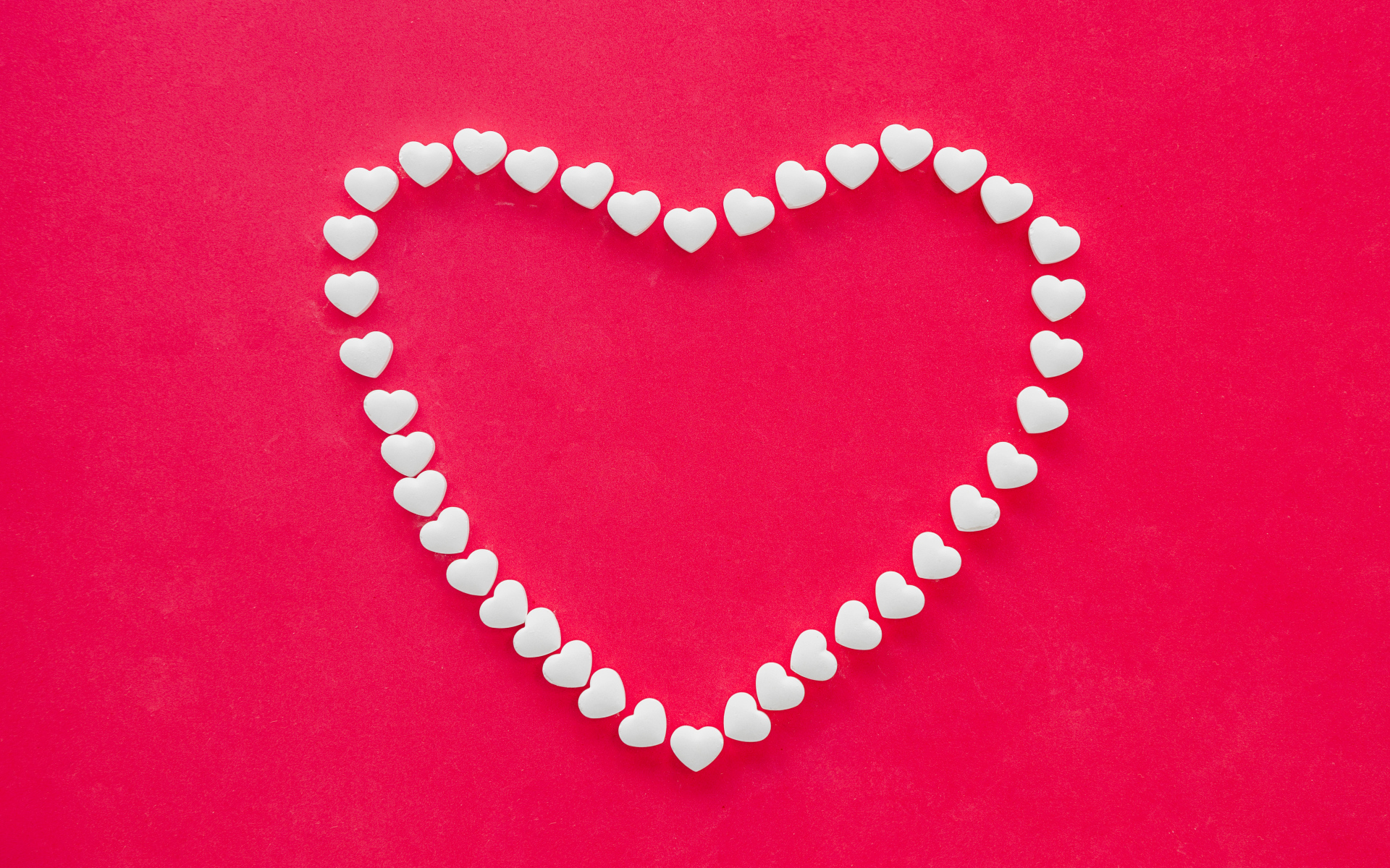 Рисунок из маленькийх белых сердечек на красном фоне