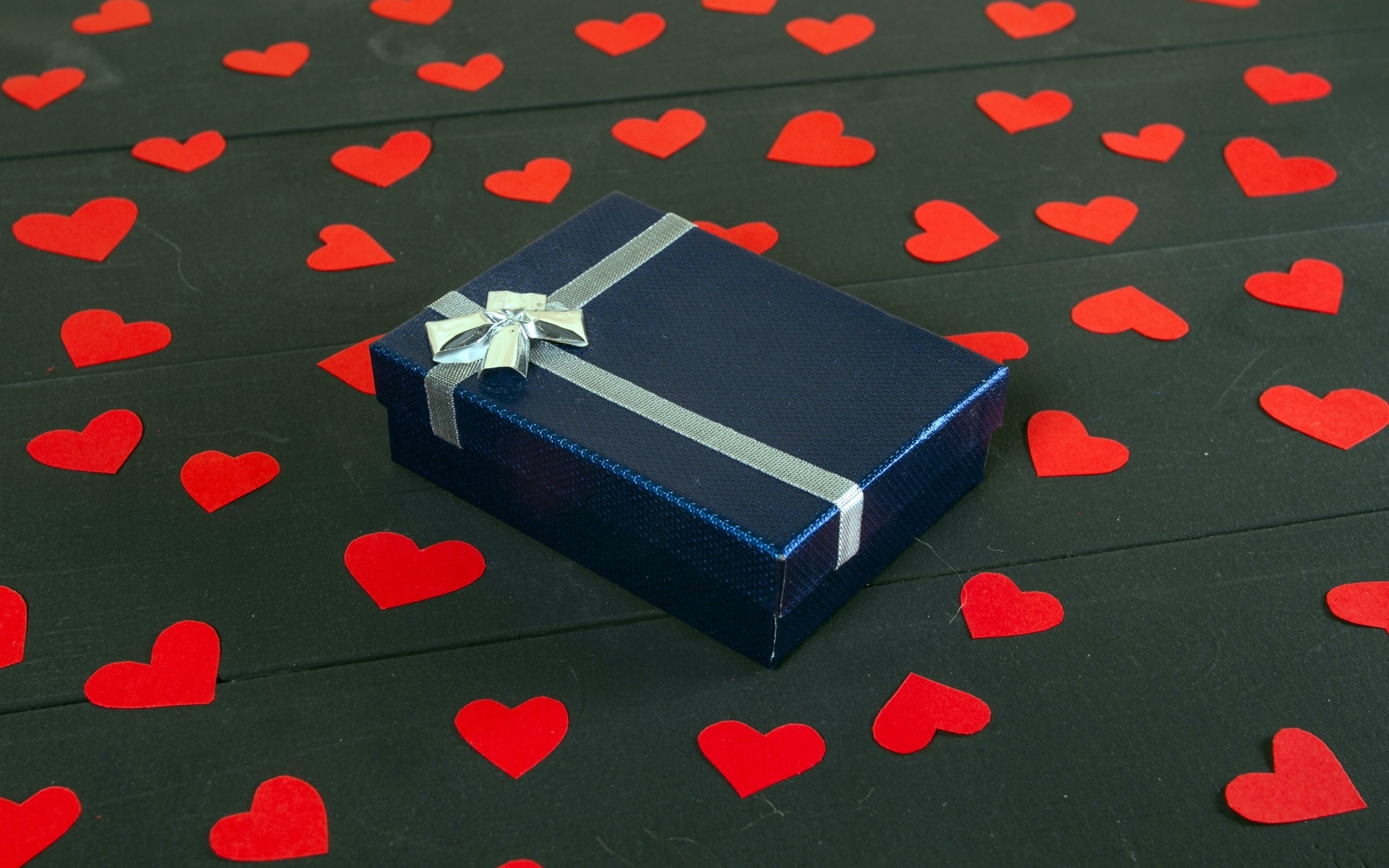 Черная коробка с красными сердечками на столе