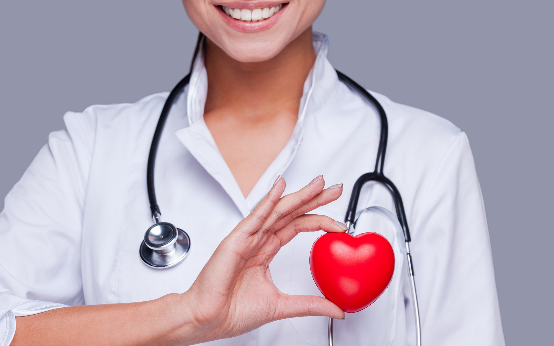 Улыбающаяся женщина врач с красным сердцем