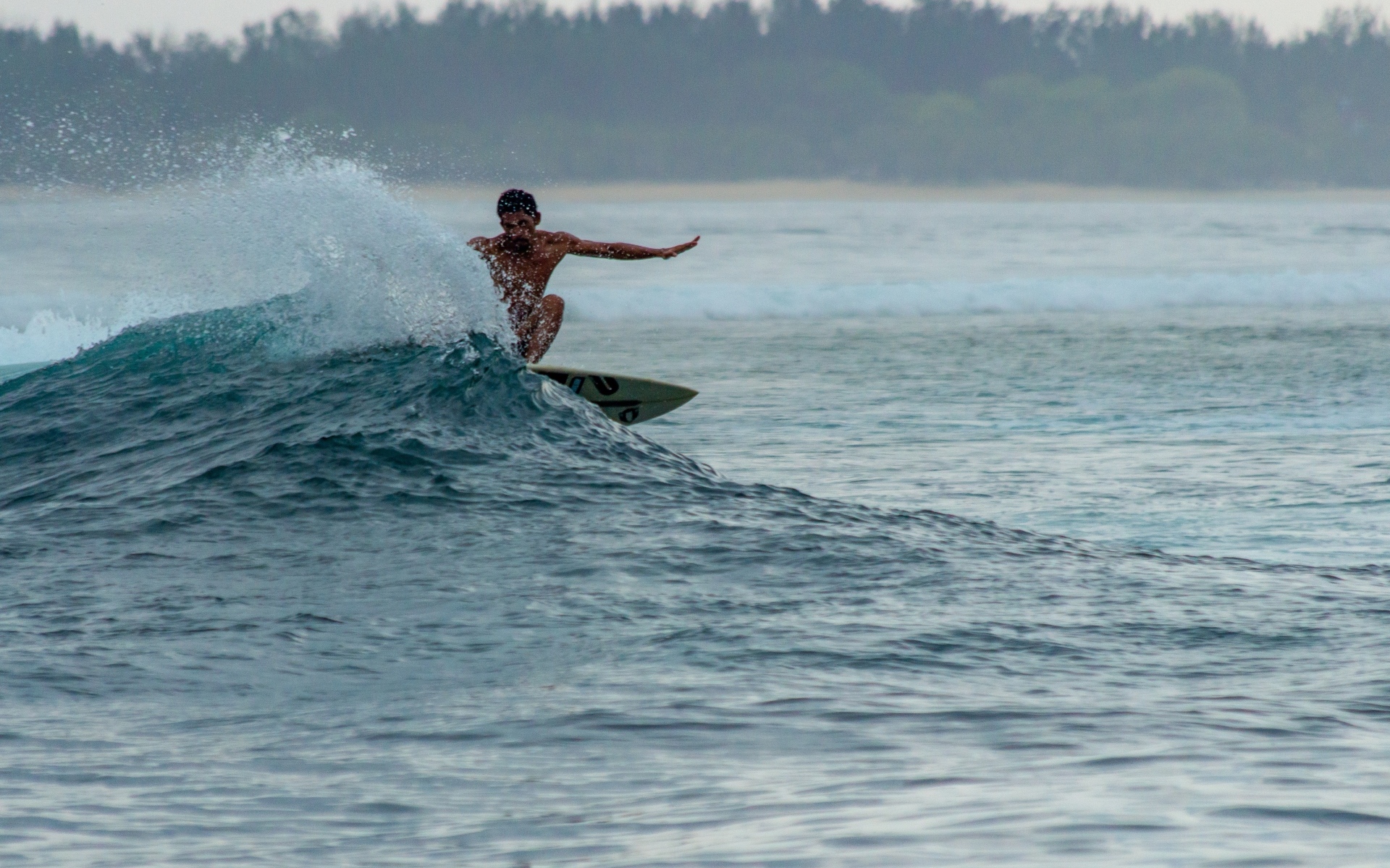Мужчина серфингист ловит волну