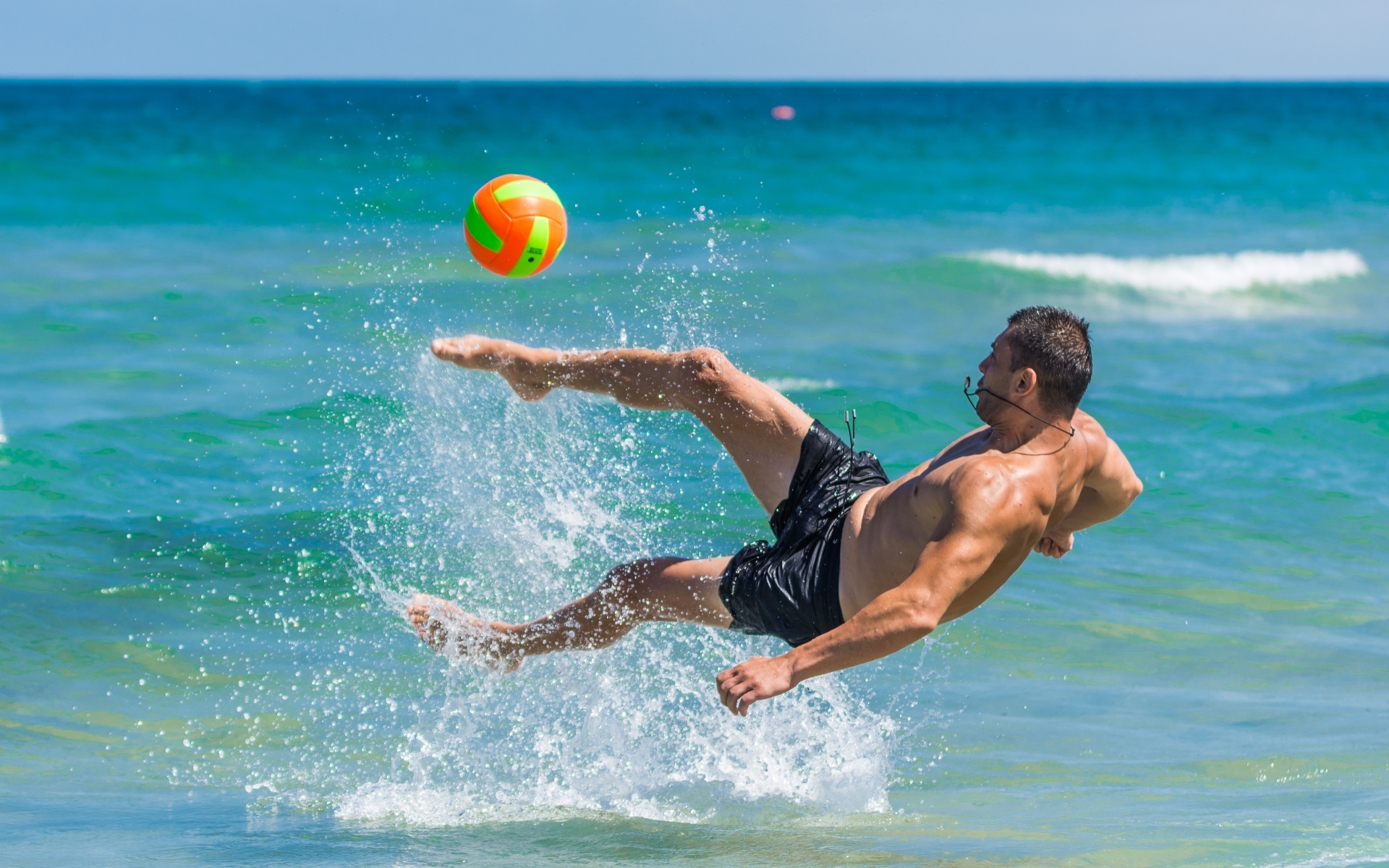 Мужчина играет в пляжный футбол