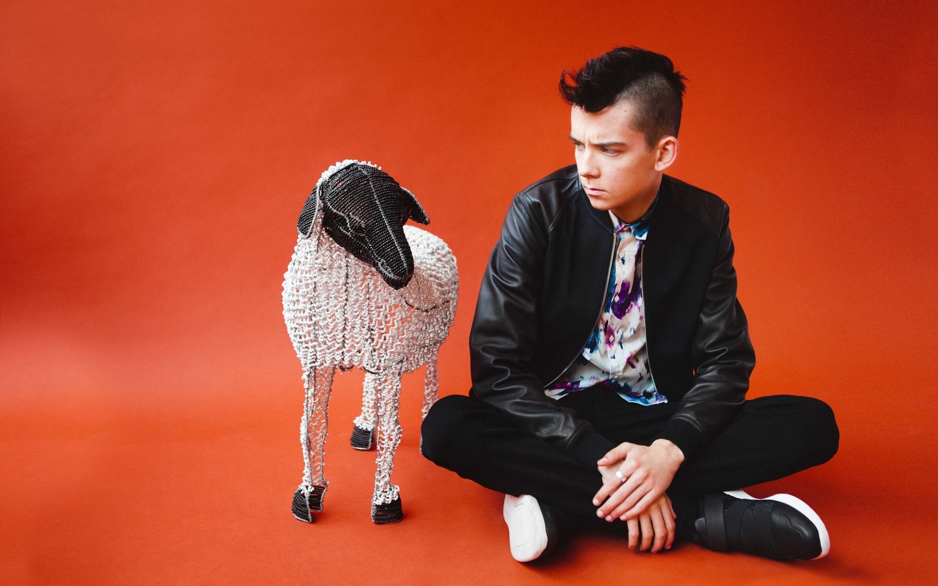 Молодой актер Эйса Баттерфилд на красном фоне