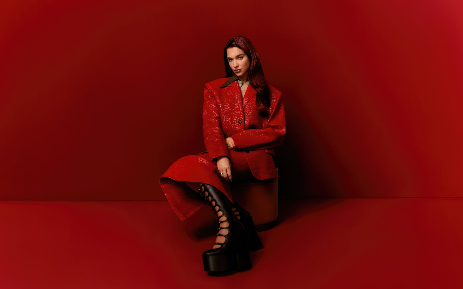 Британская певица Дуа Липа на красном фоне