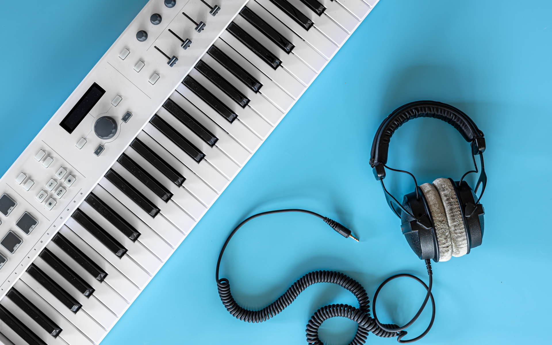 Наушники на голубом фоне с синтезатором