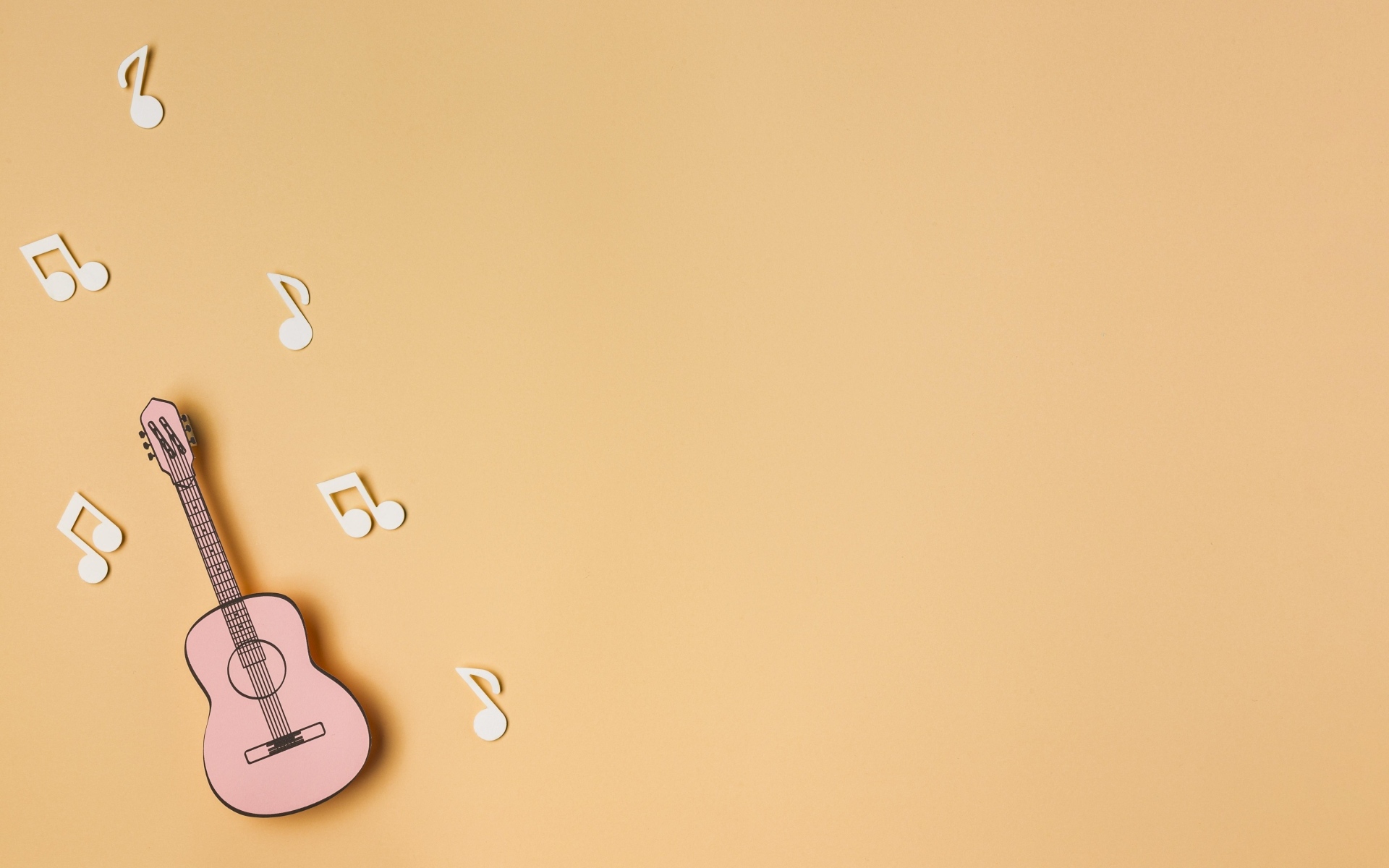 Бумажная гитара и ноты на бежевом фоне