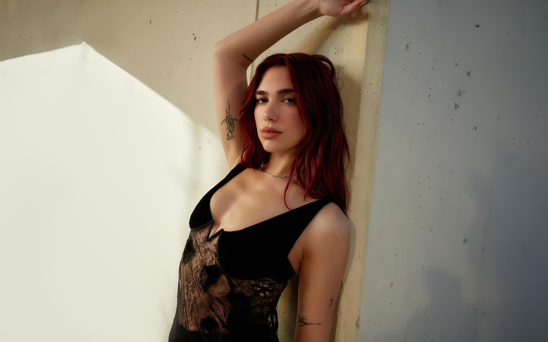 Певица Дуа Липа стоит у стены