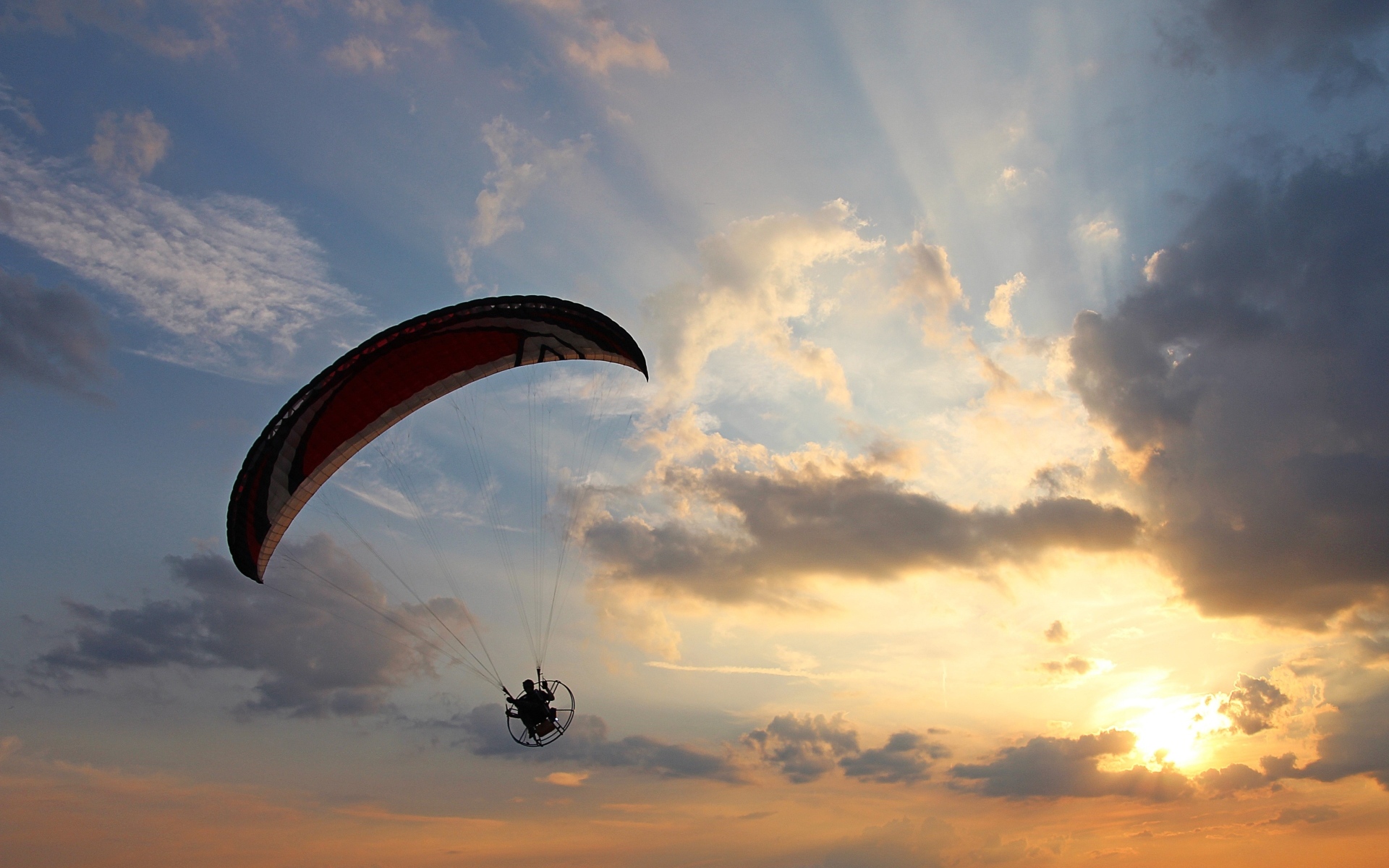 Параплан в небе на фоне солнца