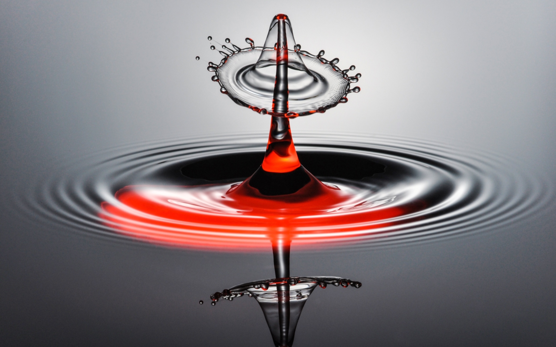 Брызги от капли воды на серой поверхности