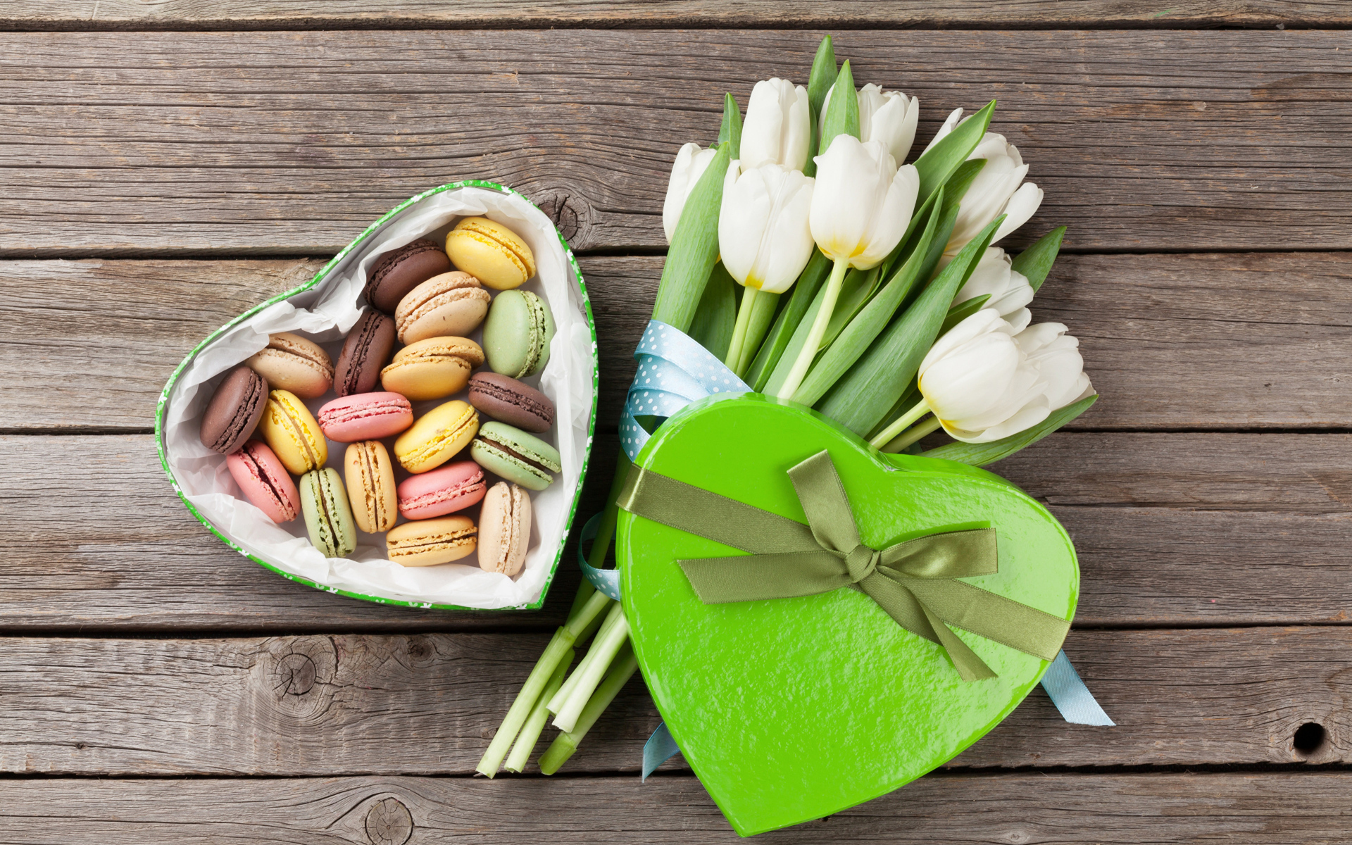 Букет белых тюльпанов на столе с коробкой печенья макарун