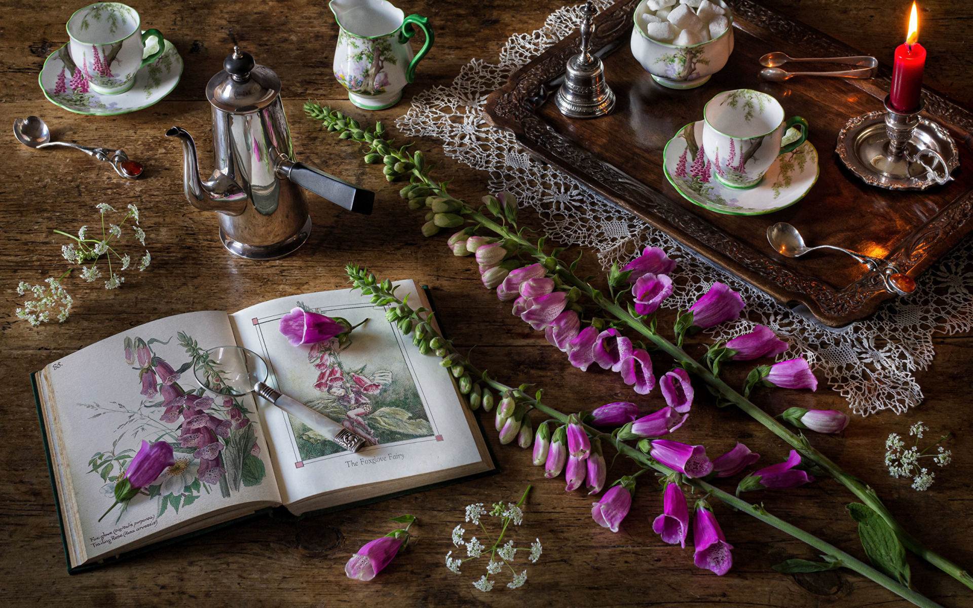 Розовые цветы на столе с книгой и чаем