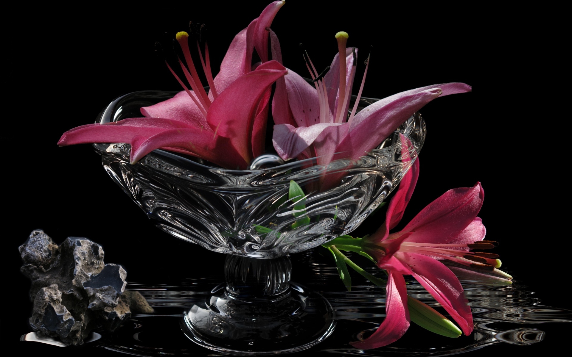 Розовые лилии в стеклянной вазе на столе