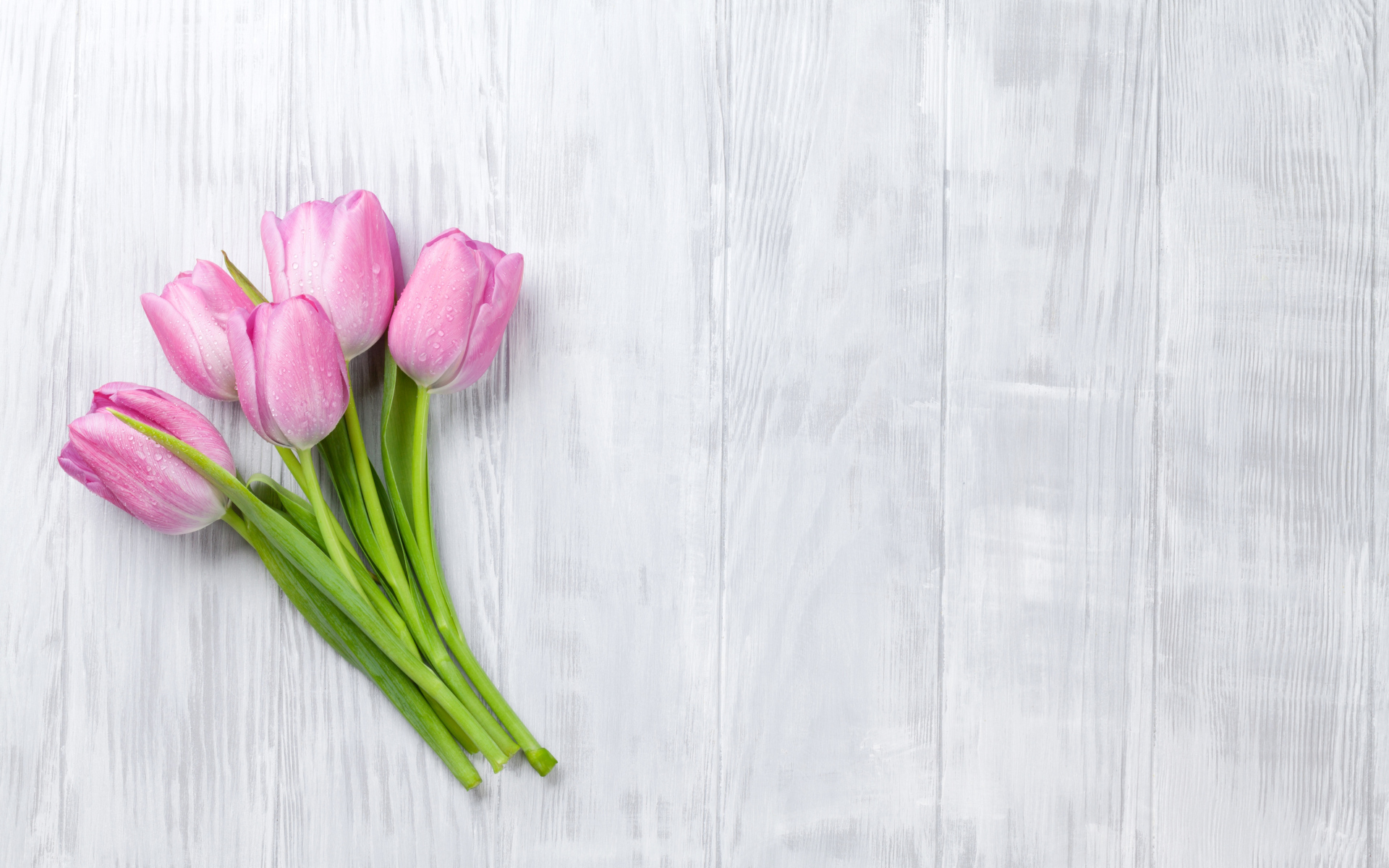 Розовые тюльпаны на сером деревянном столе