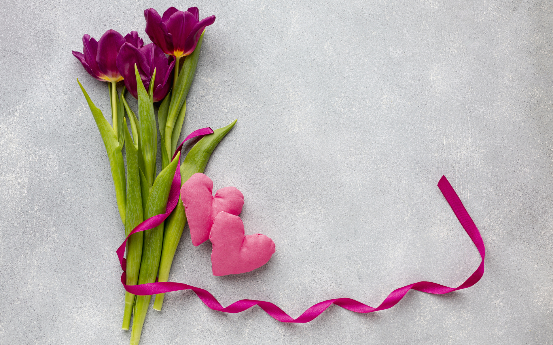 Три тюльпана, сердечко и лента на сером фоне