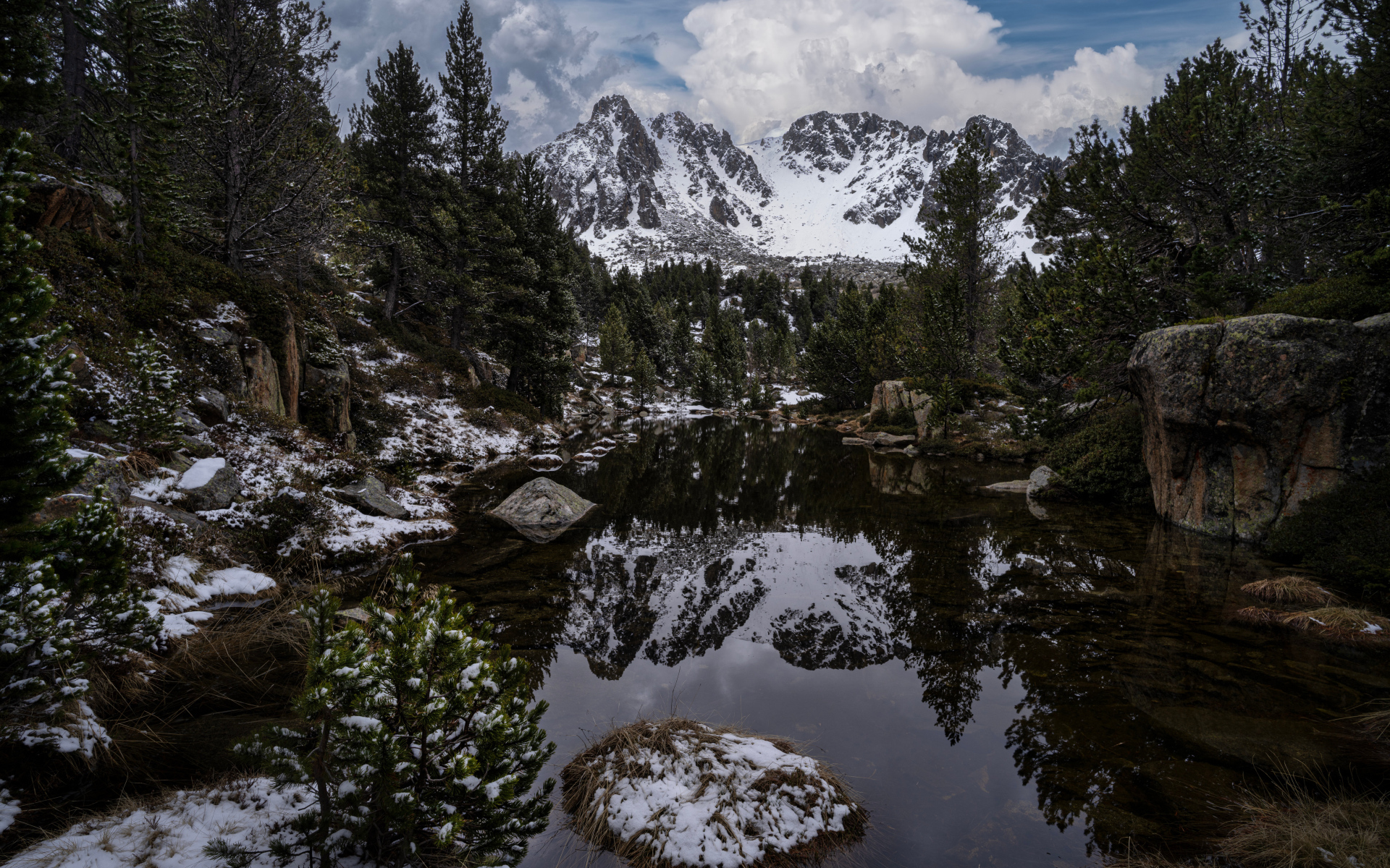 Холодная вода в озере с большими камнями на фоне гор