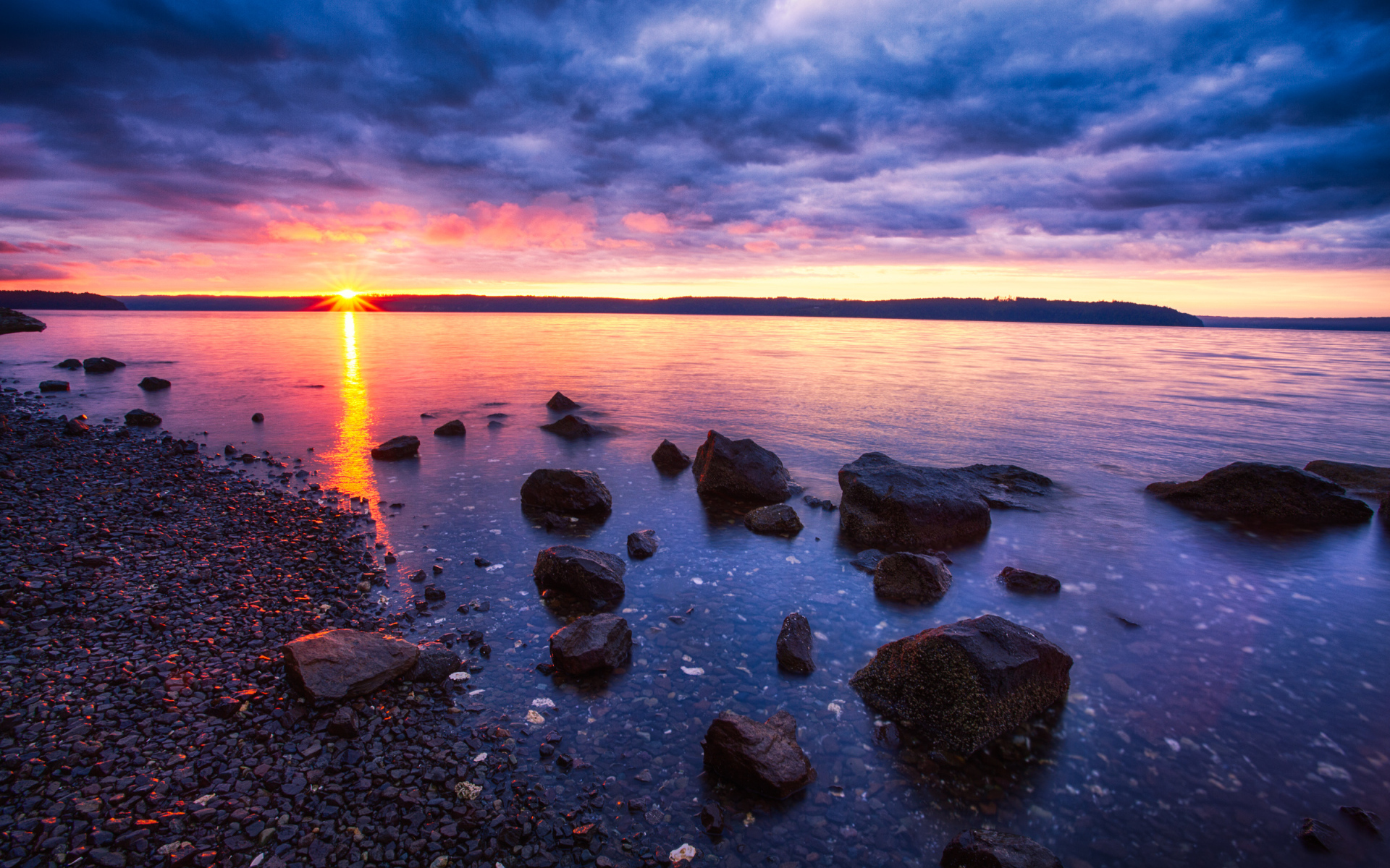 Закат солнца в пасмурном небе у озера