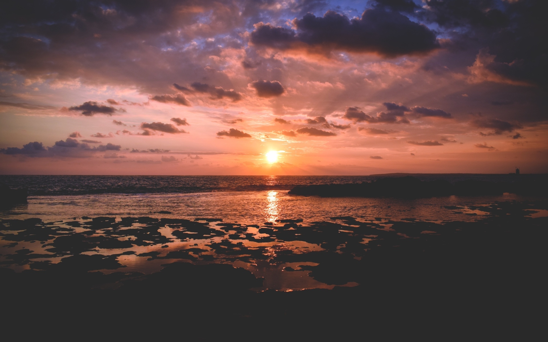 Закат яркого летнего солнца в небе над морем