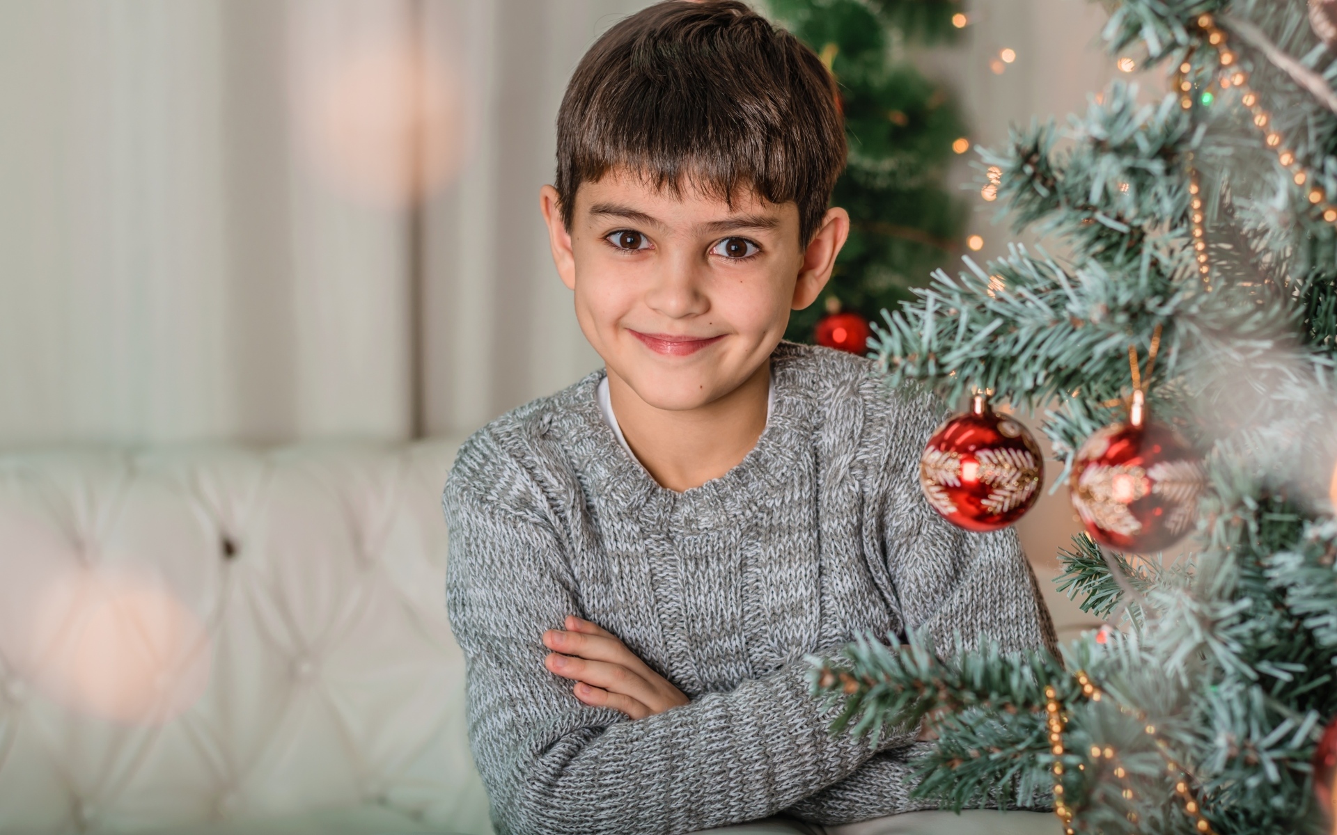 Кареглазый мальчик у новогодней ели
