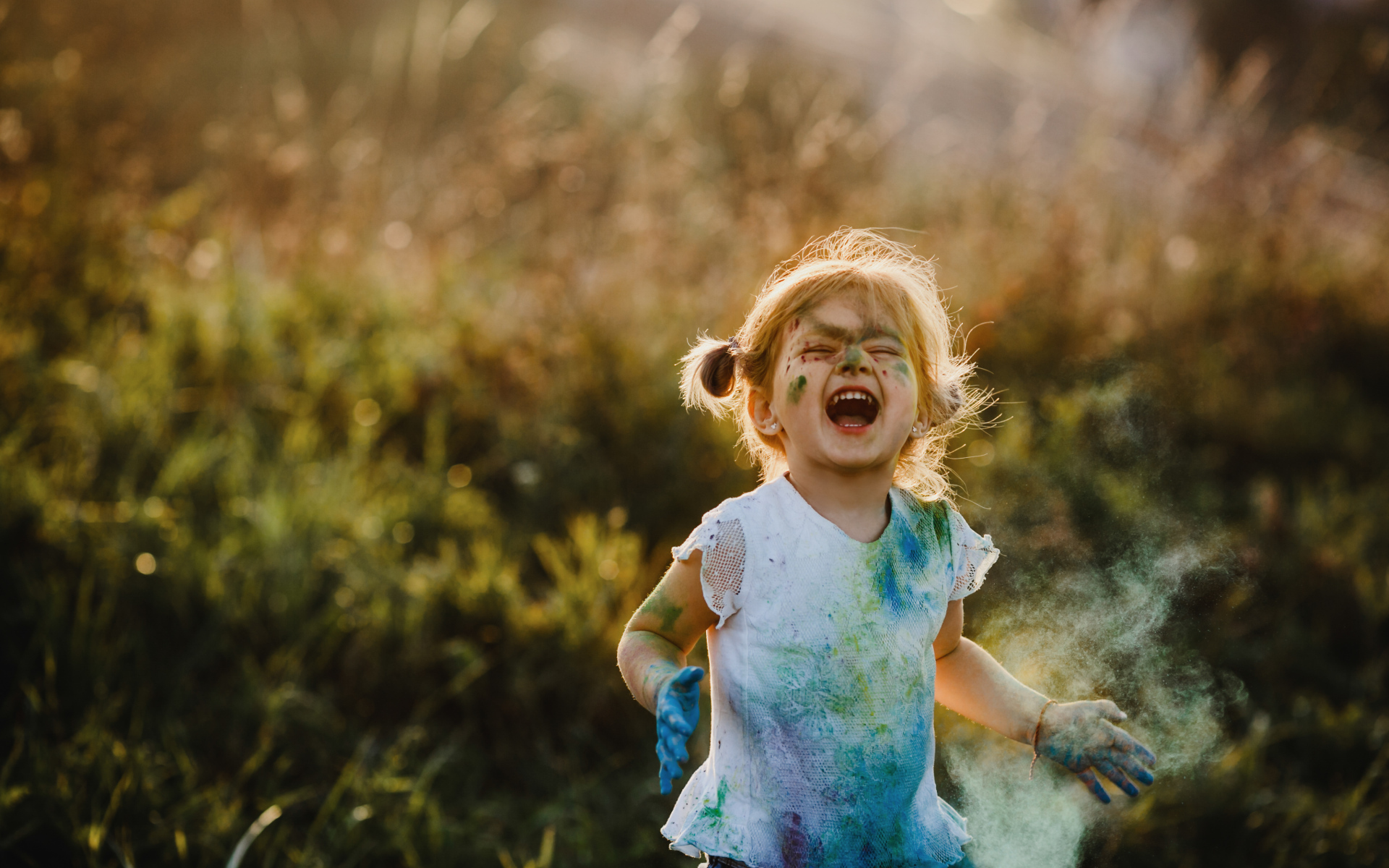 Веселая девочка в краске на улице