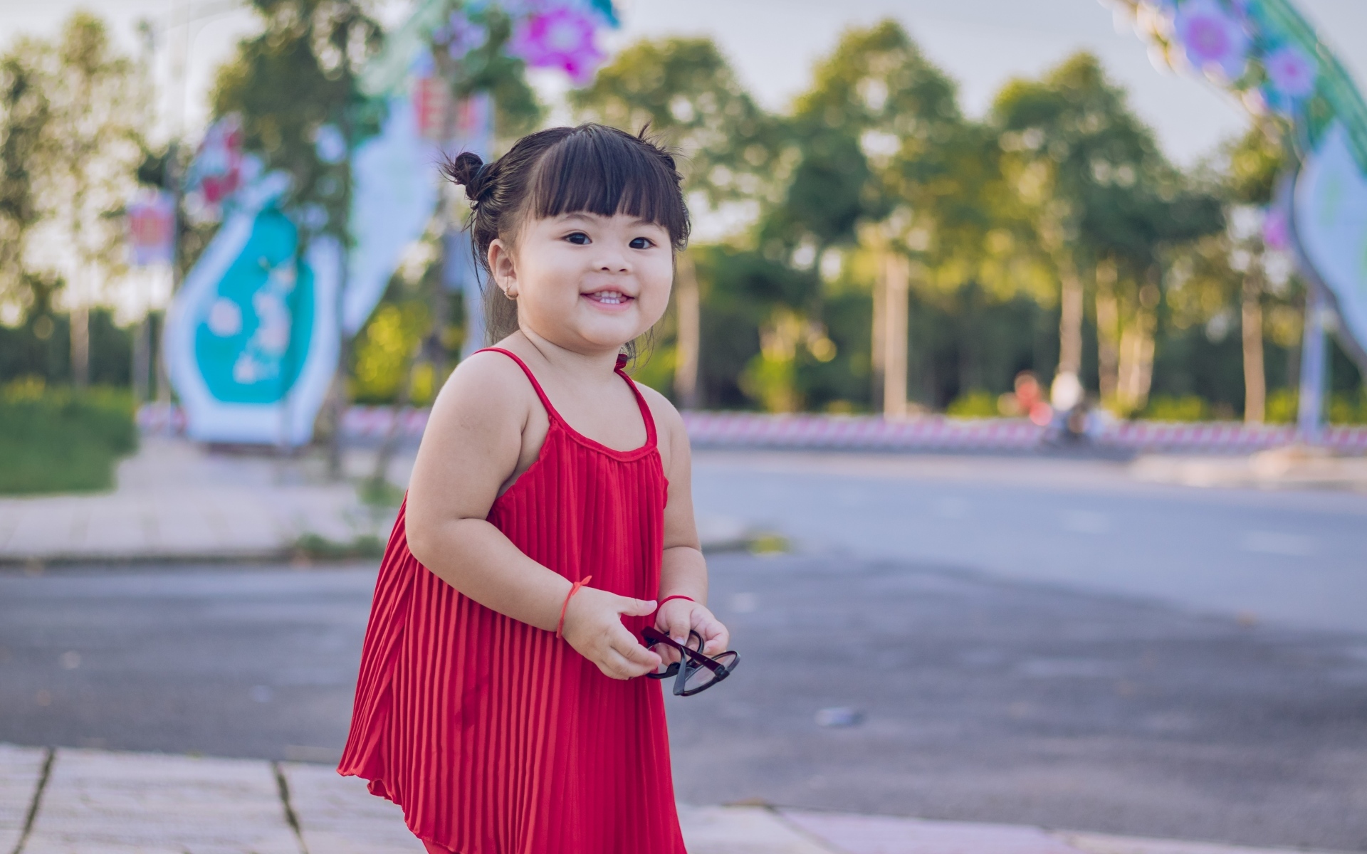 Веселая маленькая девочка азиатка в красном платье