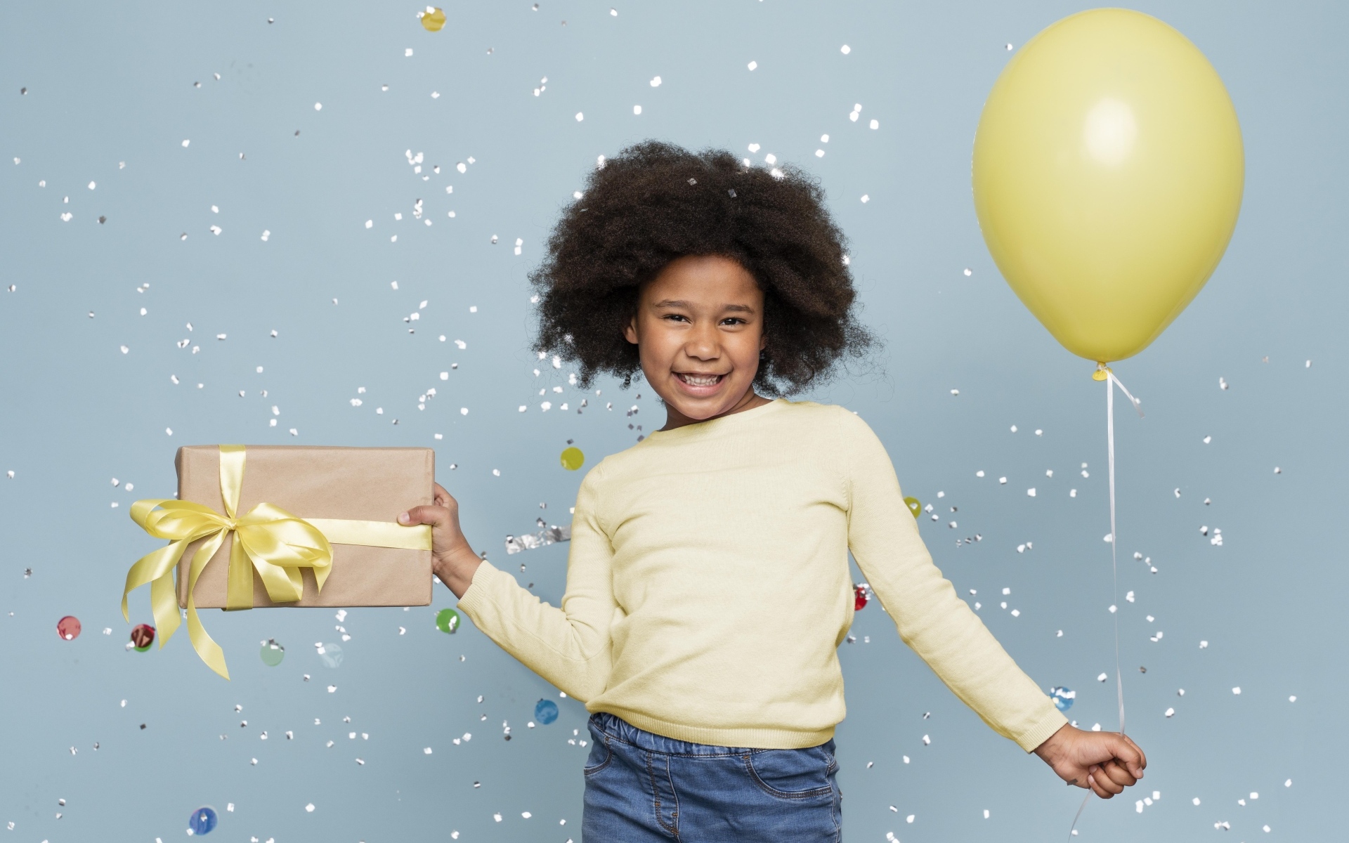Счастливая девочка с подарком и шариком на голубом фоне