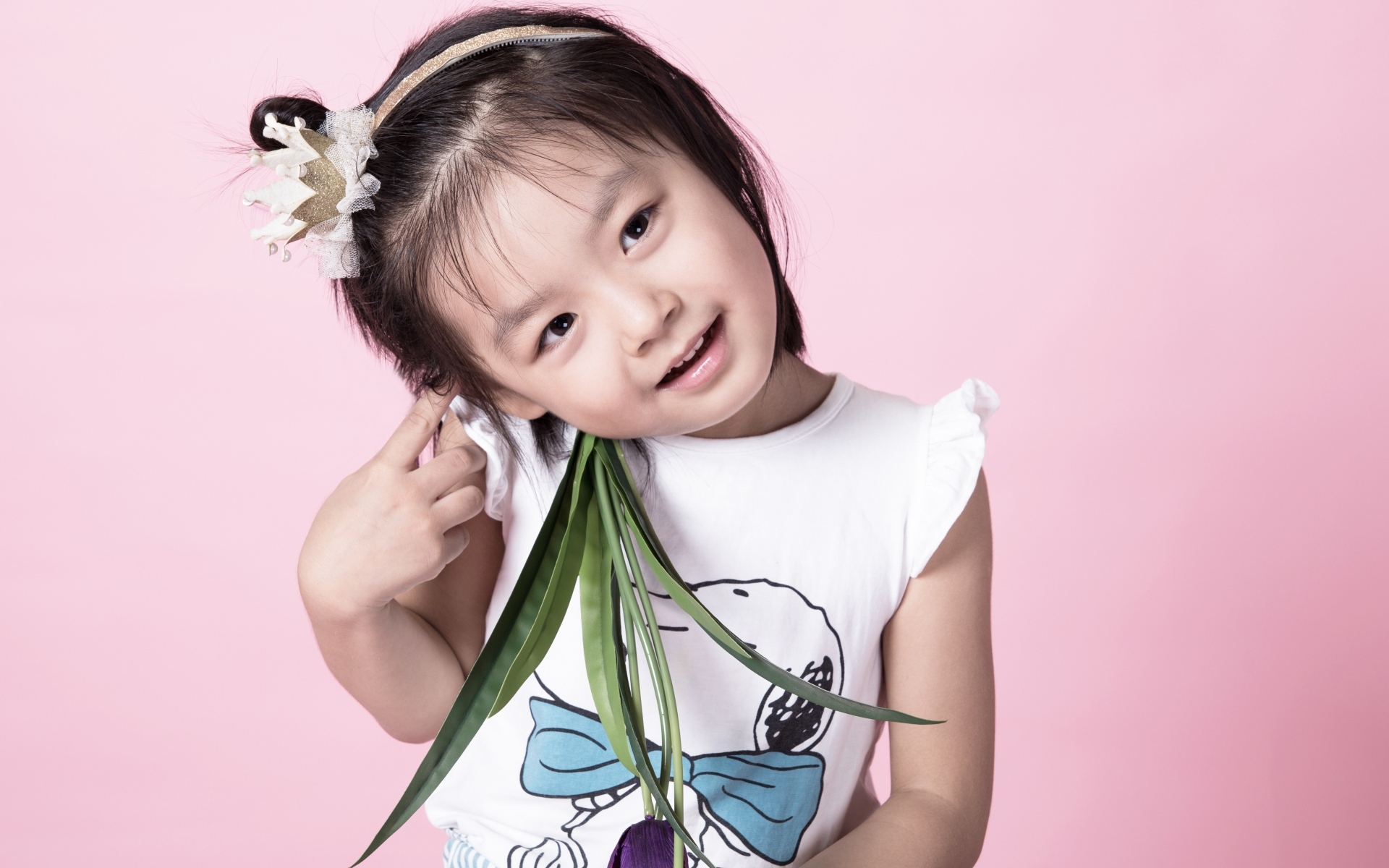 Маленькая девочка азиатка на розовом фоне