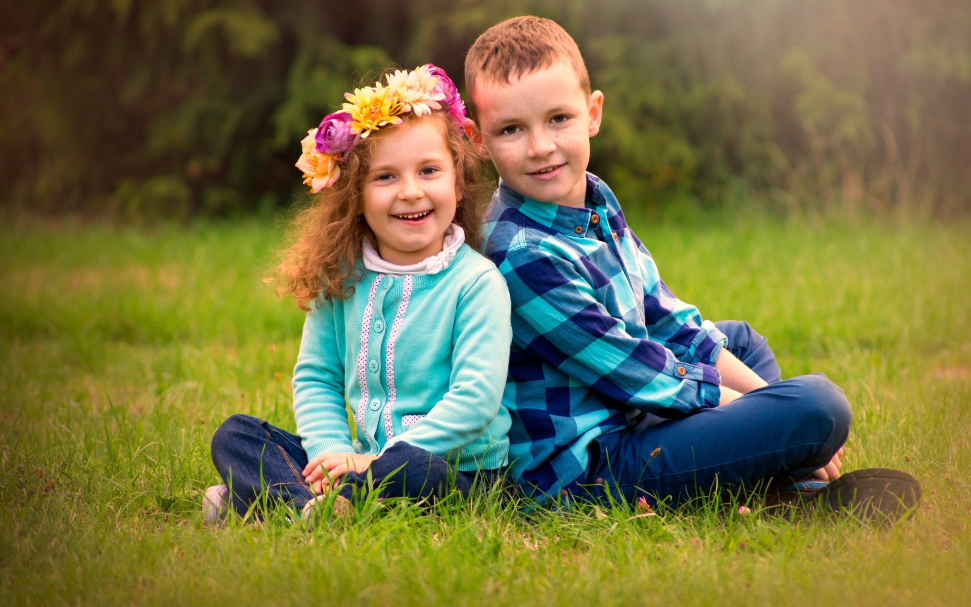 Рыжеволосые мальчик и девочка сидят на траве