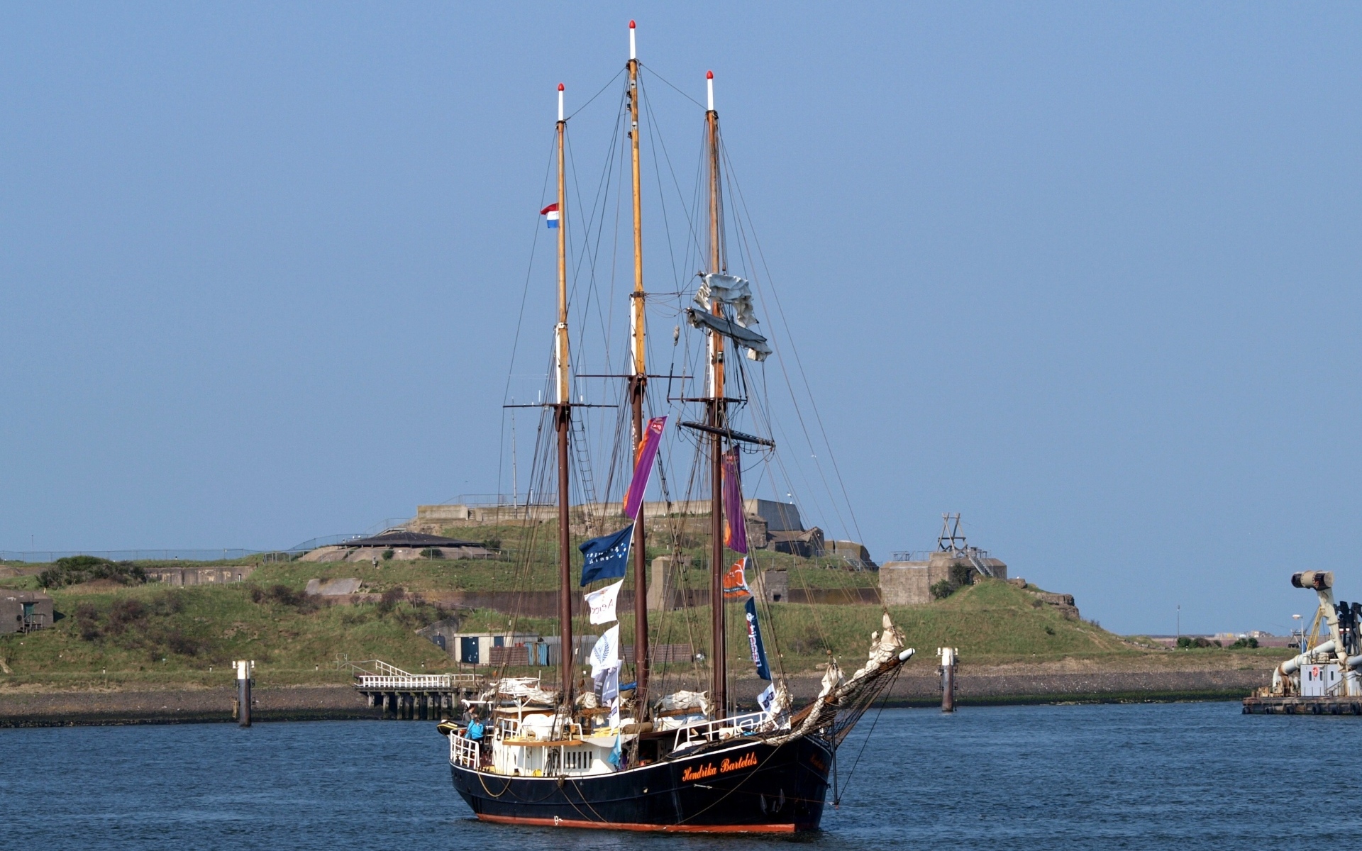 Большой корабль с опущенными парусами в гавани