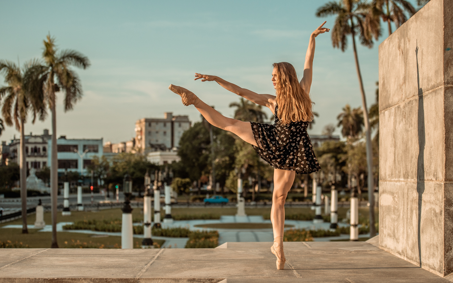 Балерина в лучах солнца у стены