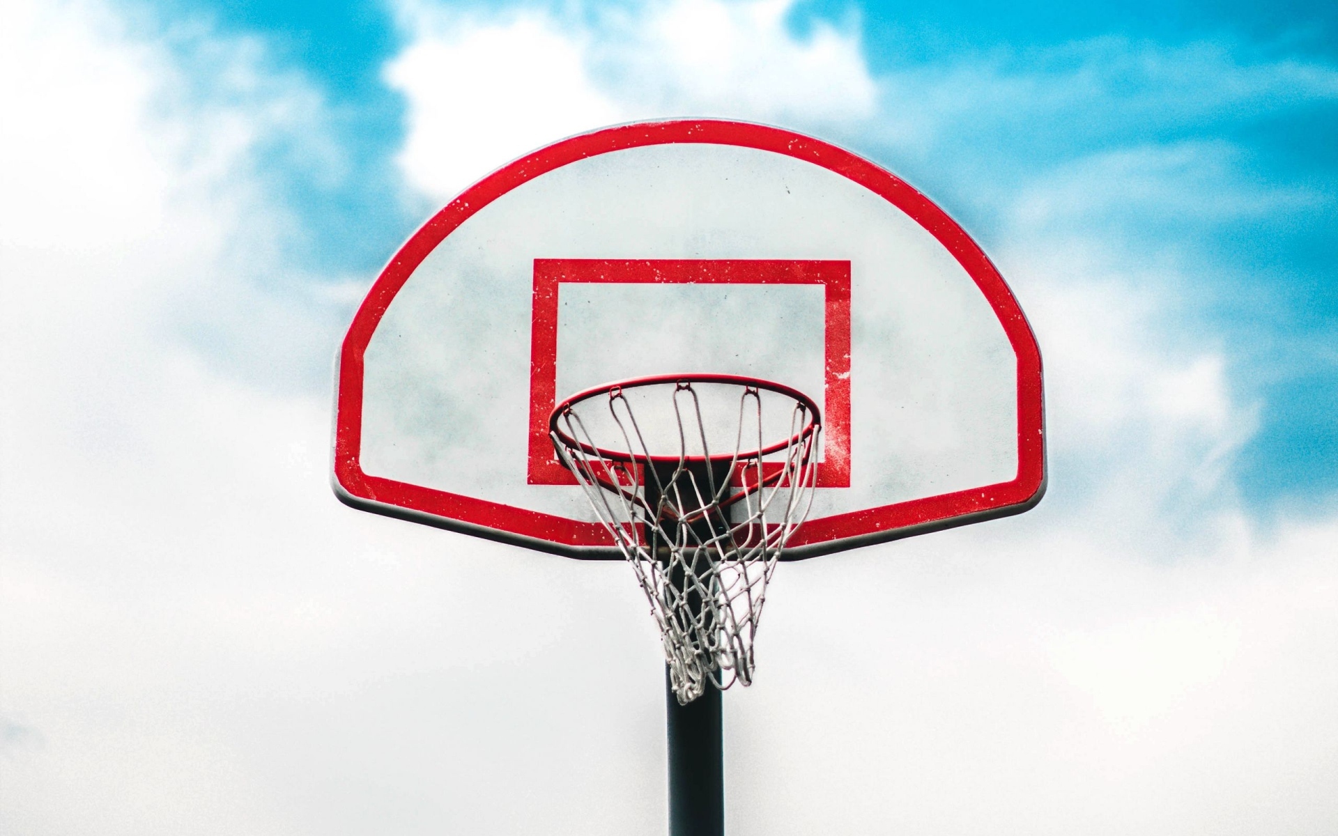 Баскетбольное кольцо на фоне белых облаков