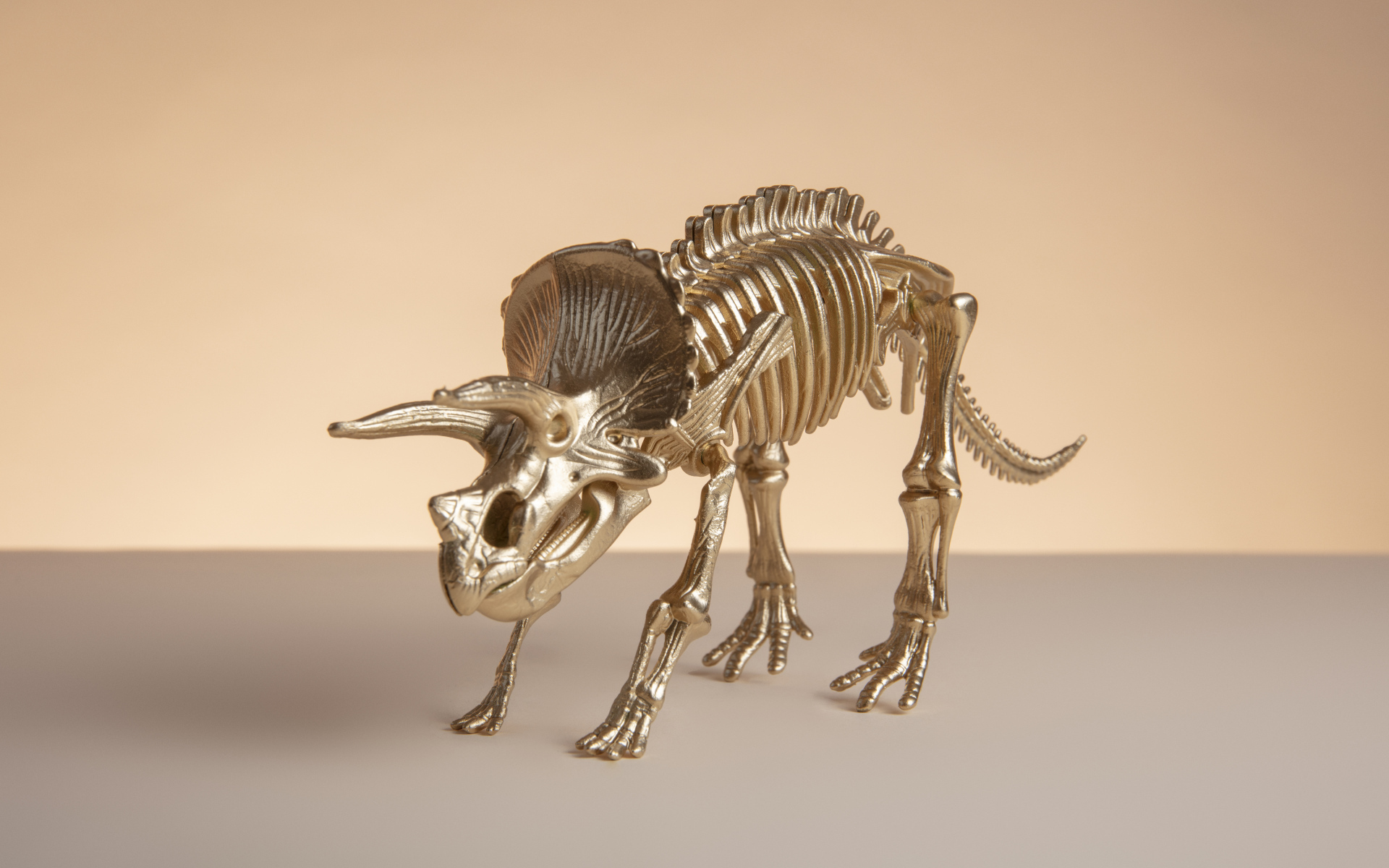 Золотой скелет динозавра на коричневом фоне