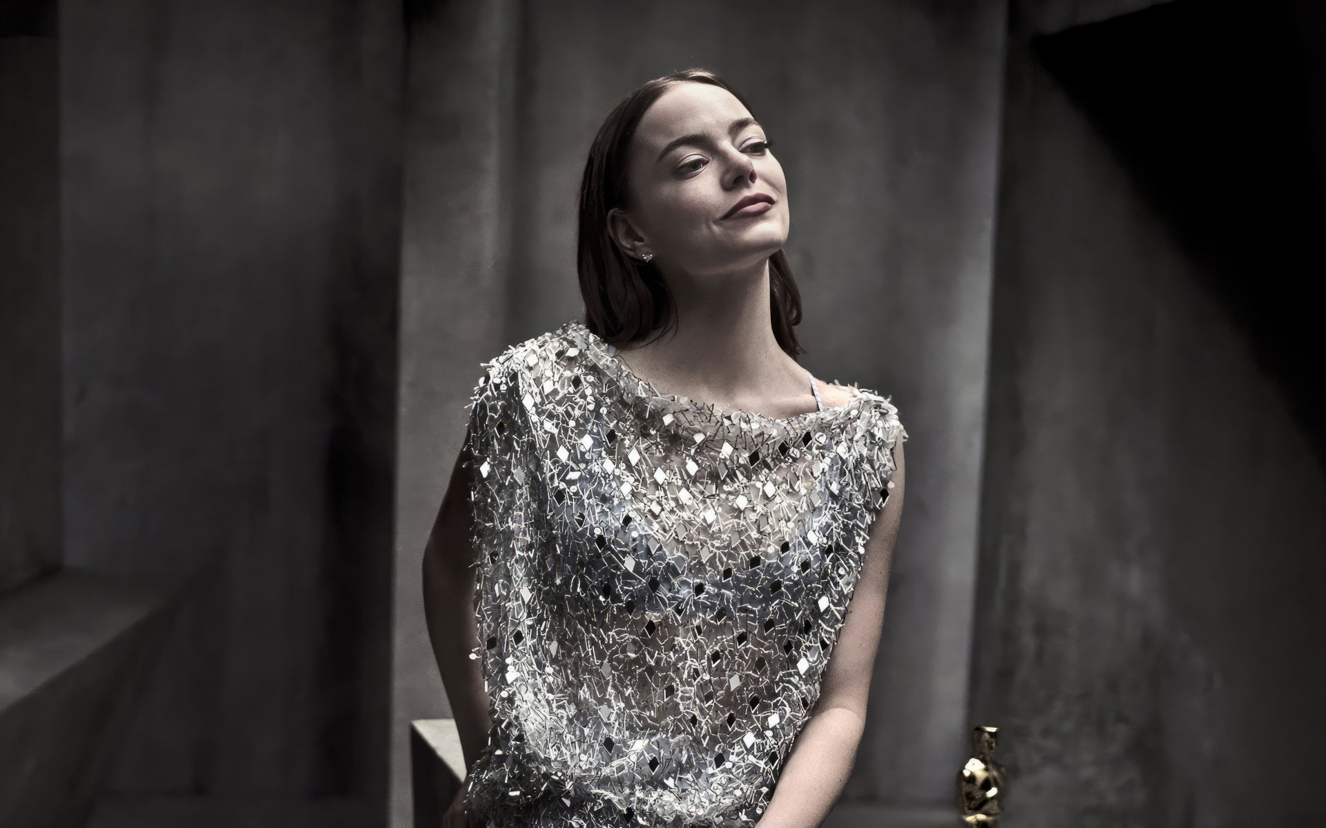 Рыжеволосая актриса Эмма Стоун в блестящем платье в серой комнате