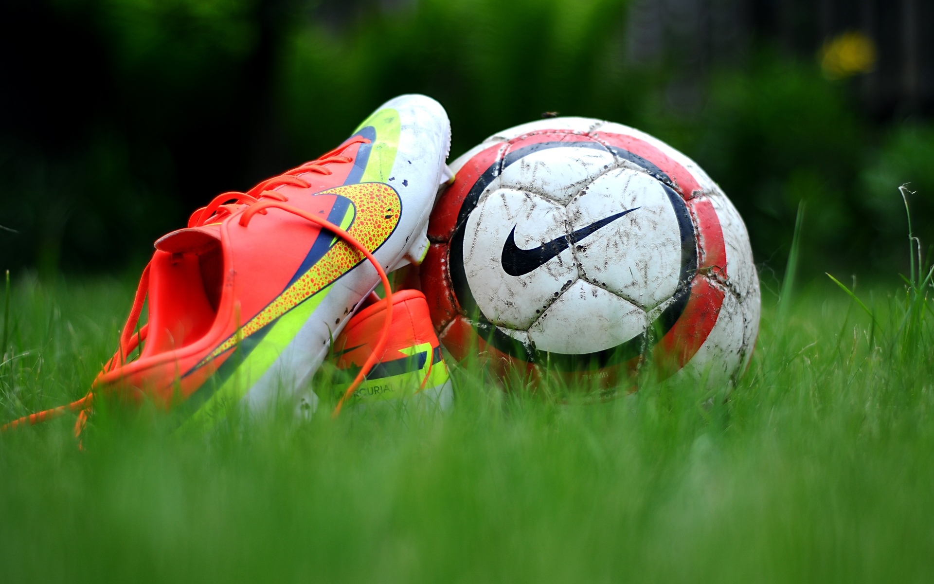 Футбольный мяч и бутсу на зеленой траве