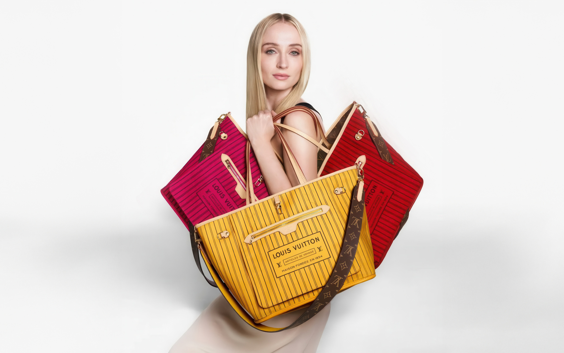 Софи Тернер с сумками Луи Виттон на белом фоне