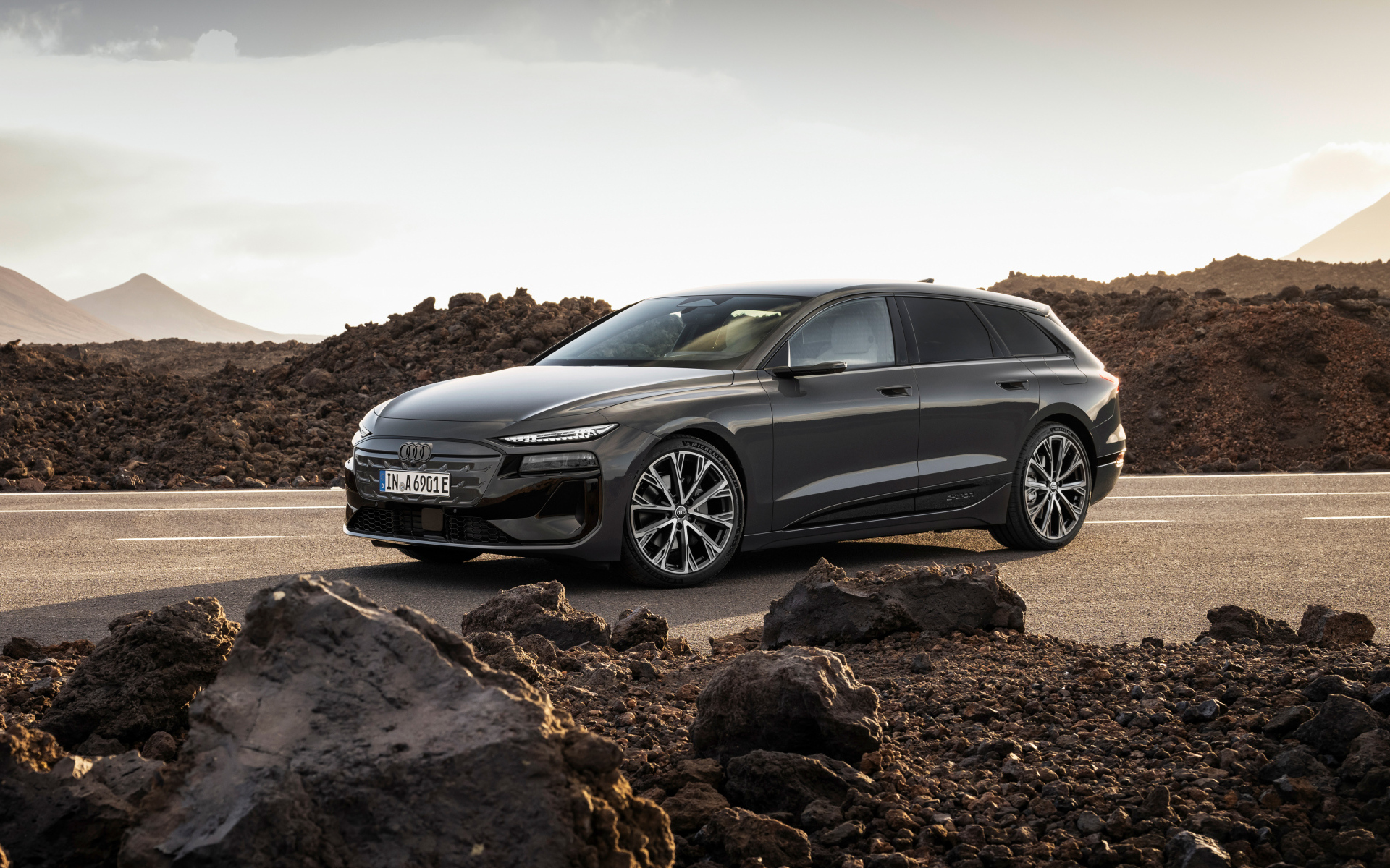 Автомобиль Audi A6 Avant e-tron S line 2024 года на дороге с камнями