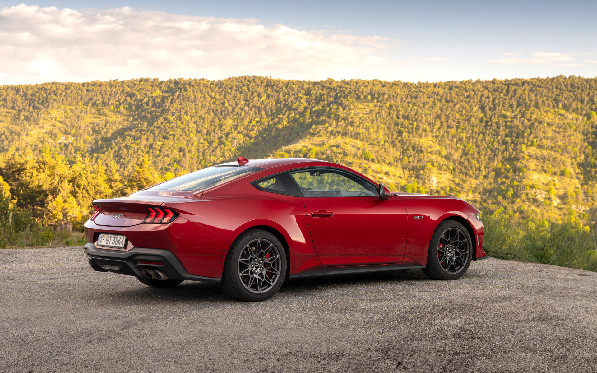 Красный автомобиль Ford Mustang GT 2024 года вид сзади